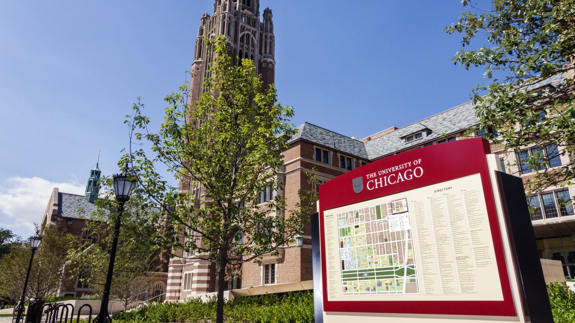 Photo of a tall buidling and a sign welcoming you to a college. 
