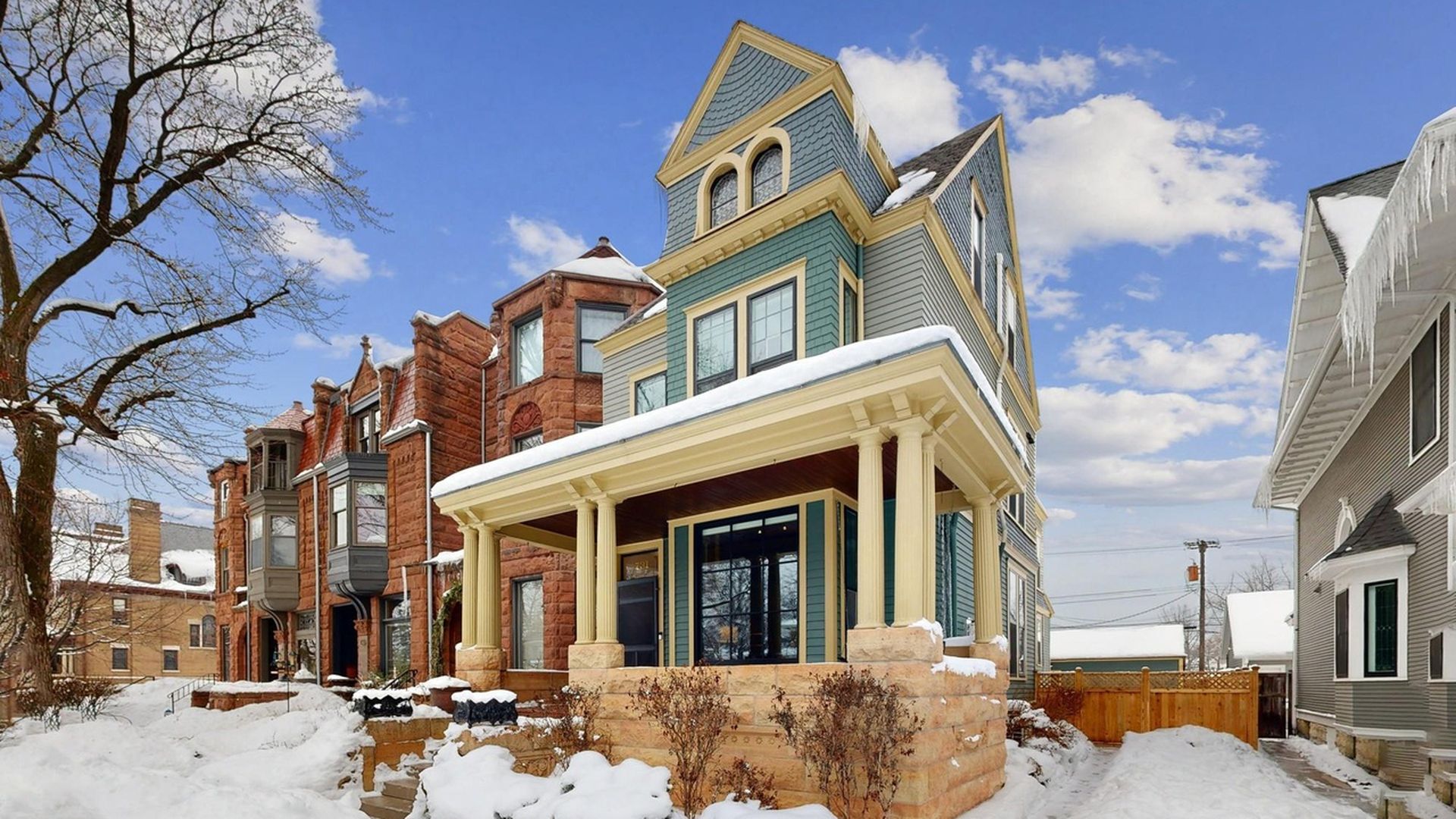 A snowy row home next to brownstones