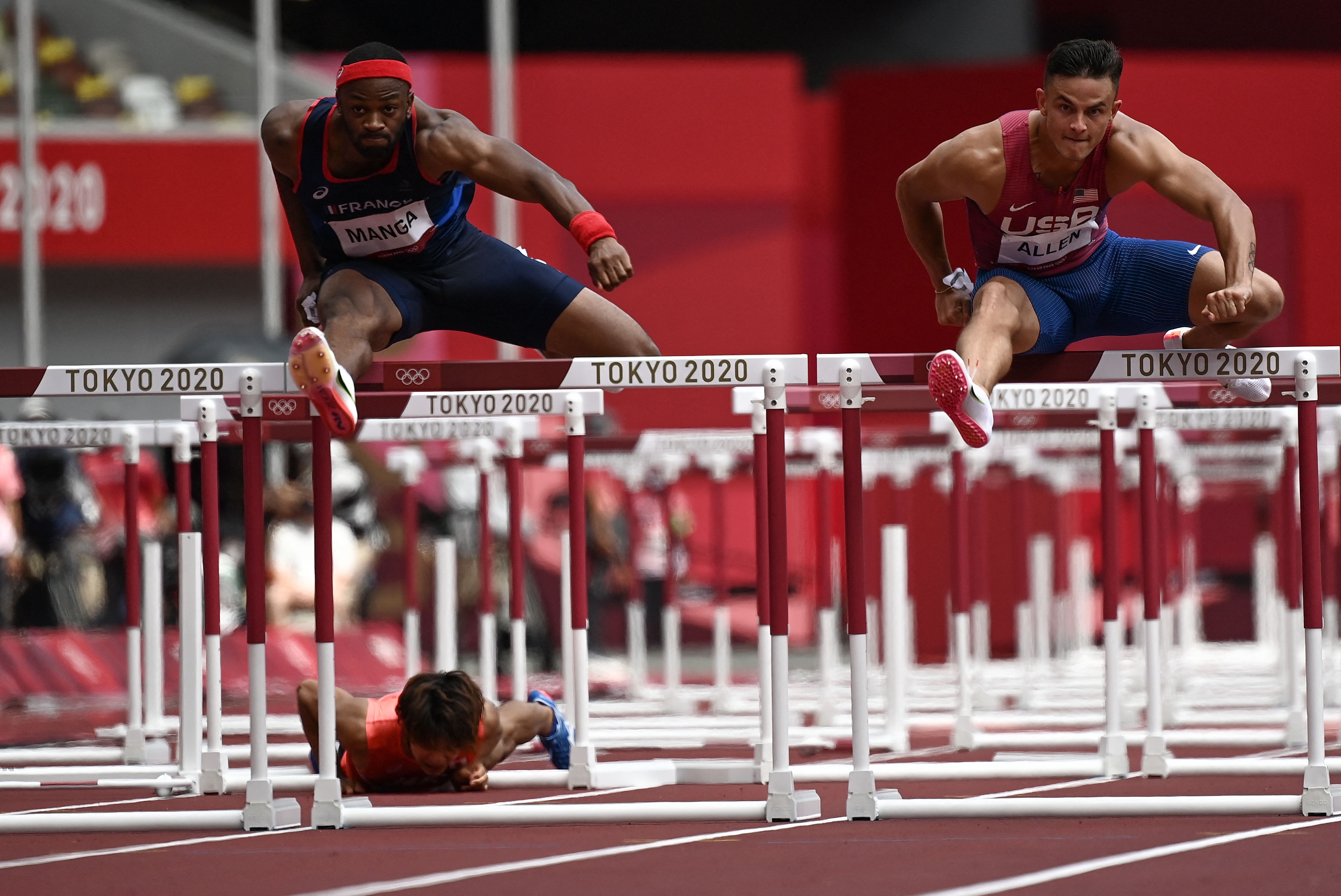 USA's Devon Allen (R) wins ahead of France's Aurel Manga (L) and Japan's Taio Kanai who fell in the men's 110m hurdles semi-finals at the Tokyo Games