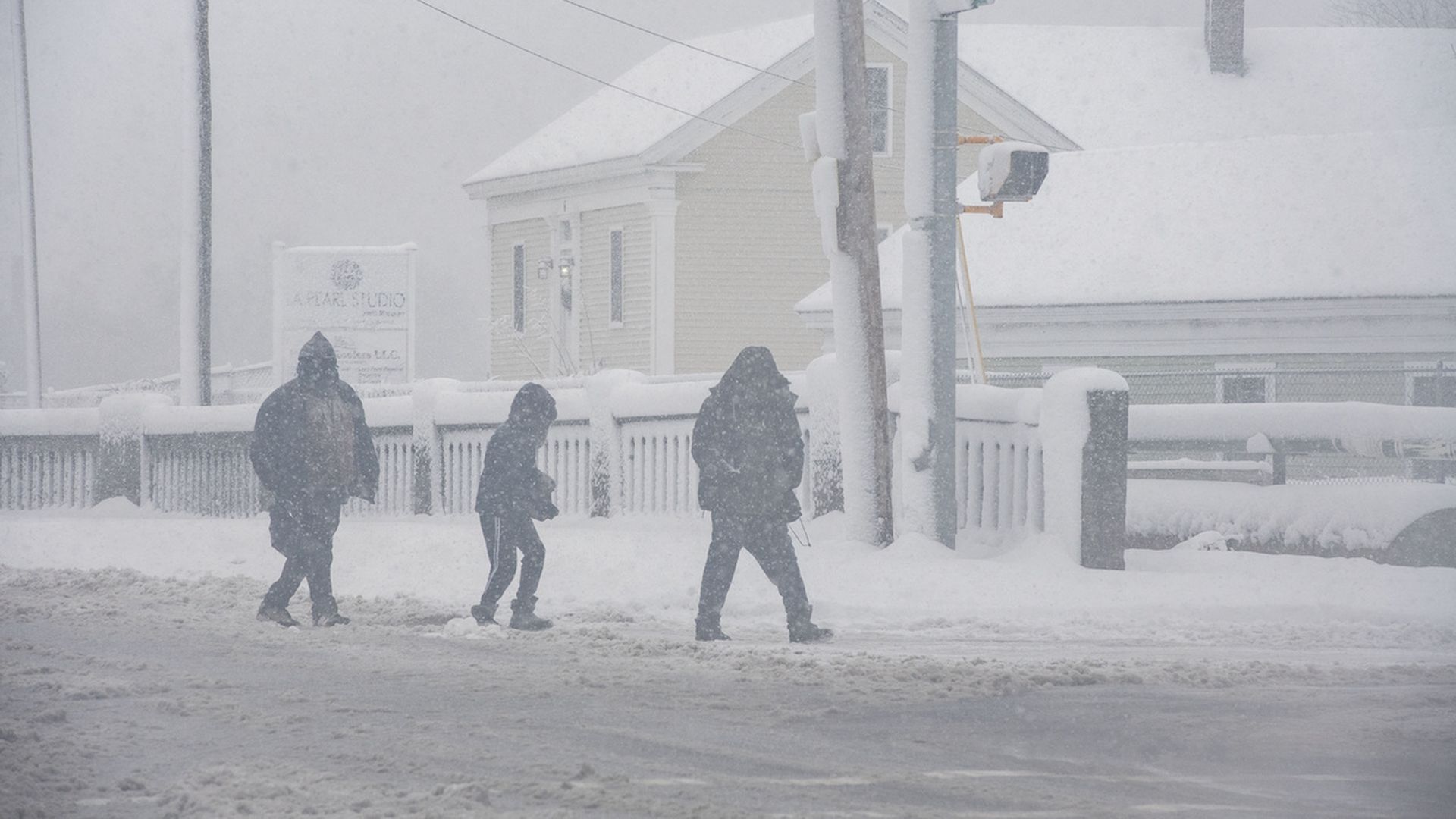 People walk amid heavy snow falling in Massachusetts in January.