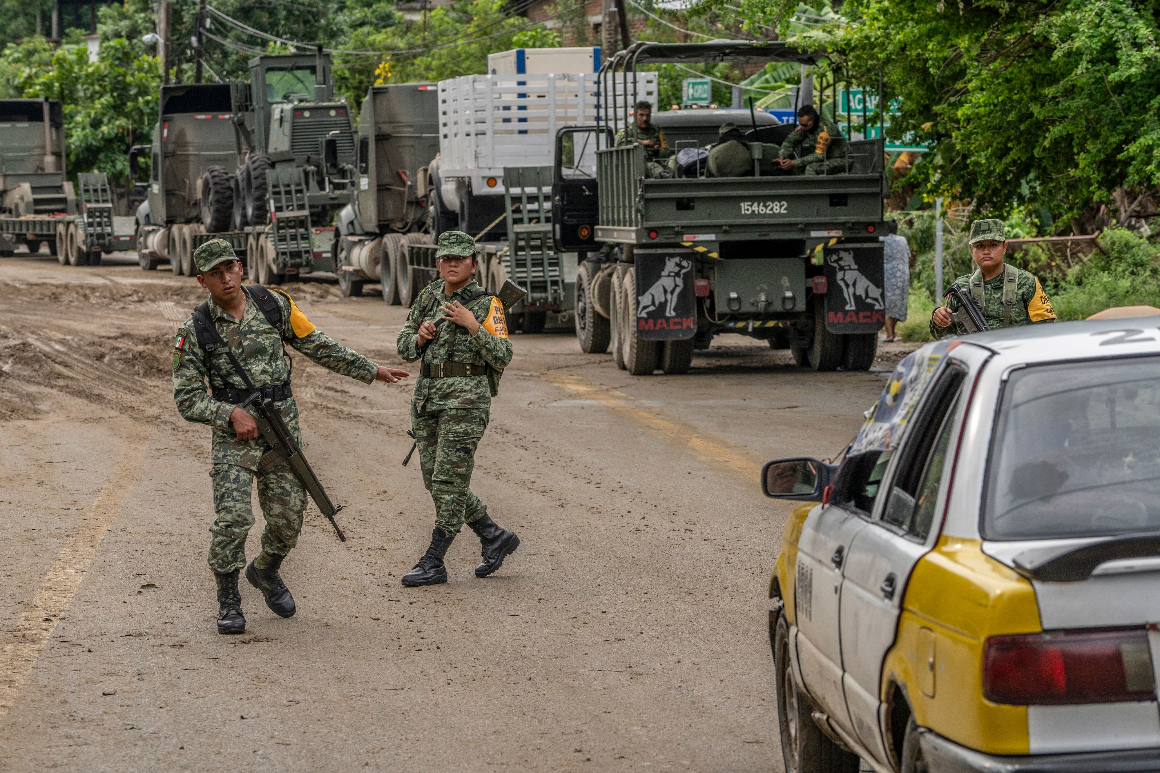 Mexican Army soldiers stranded as they wait for the engineer corps to fix a fallen bridge in the aftermath of Hurricane Otis near Xaltianguis, Guerrero state, Mexico, on Thursday, Oct. 26, 2023. 