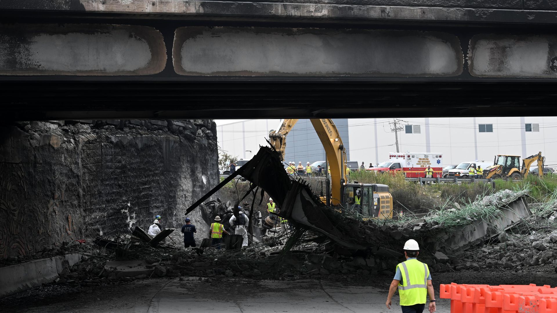 A collapsed section of the bridge is in the background, with smoke damaged foreground