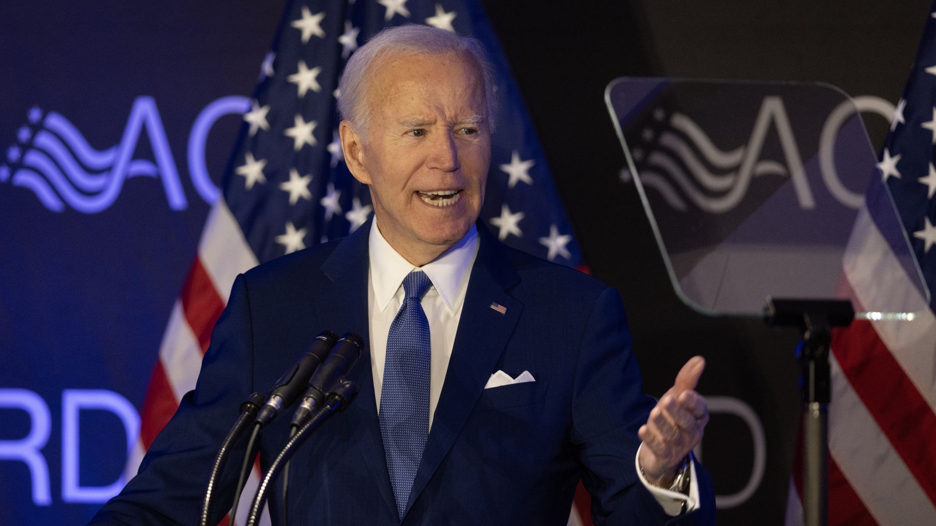 Former President Biden gestures as he speaks during a conference.