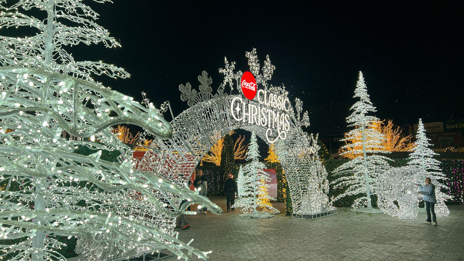 An archway covered in white lights with a sign that says Classic Christmas. 