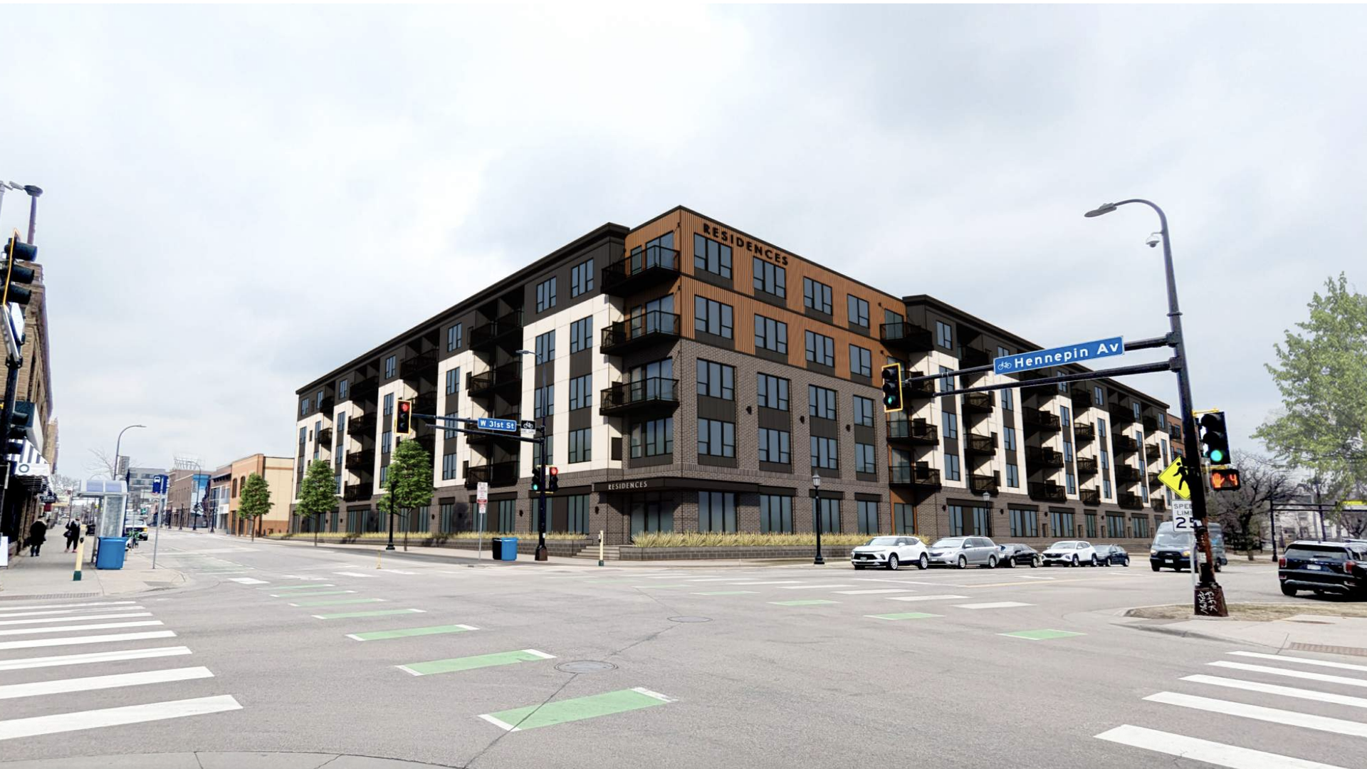 Intersection of W 31st St and Hennepin Av with a modern five-story apartment building labeled "Residences", brick and wood exterior, traffic lights, crosswalks, and parked cars.