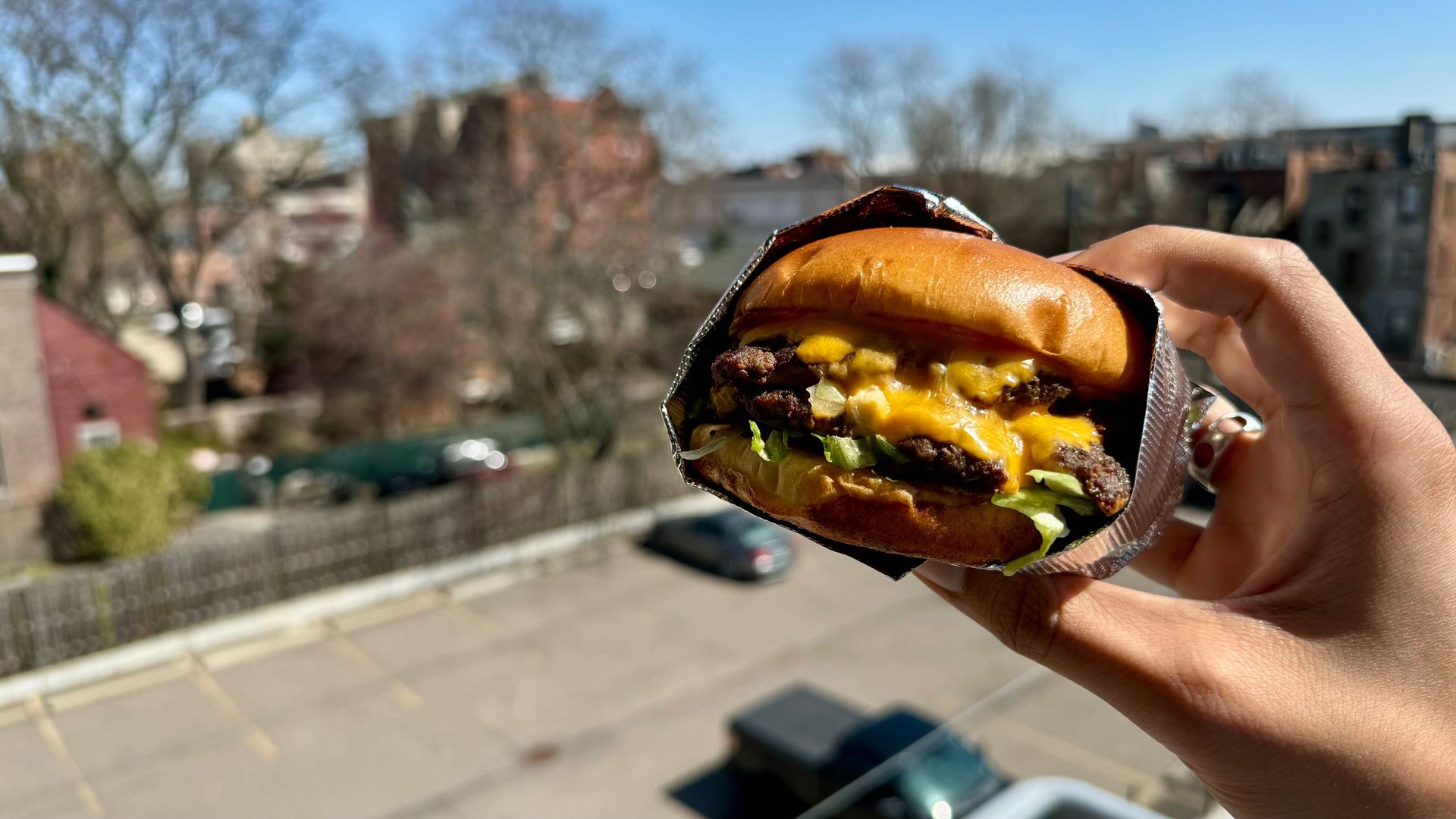 A burger inside foil with melty cheese.