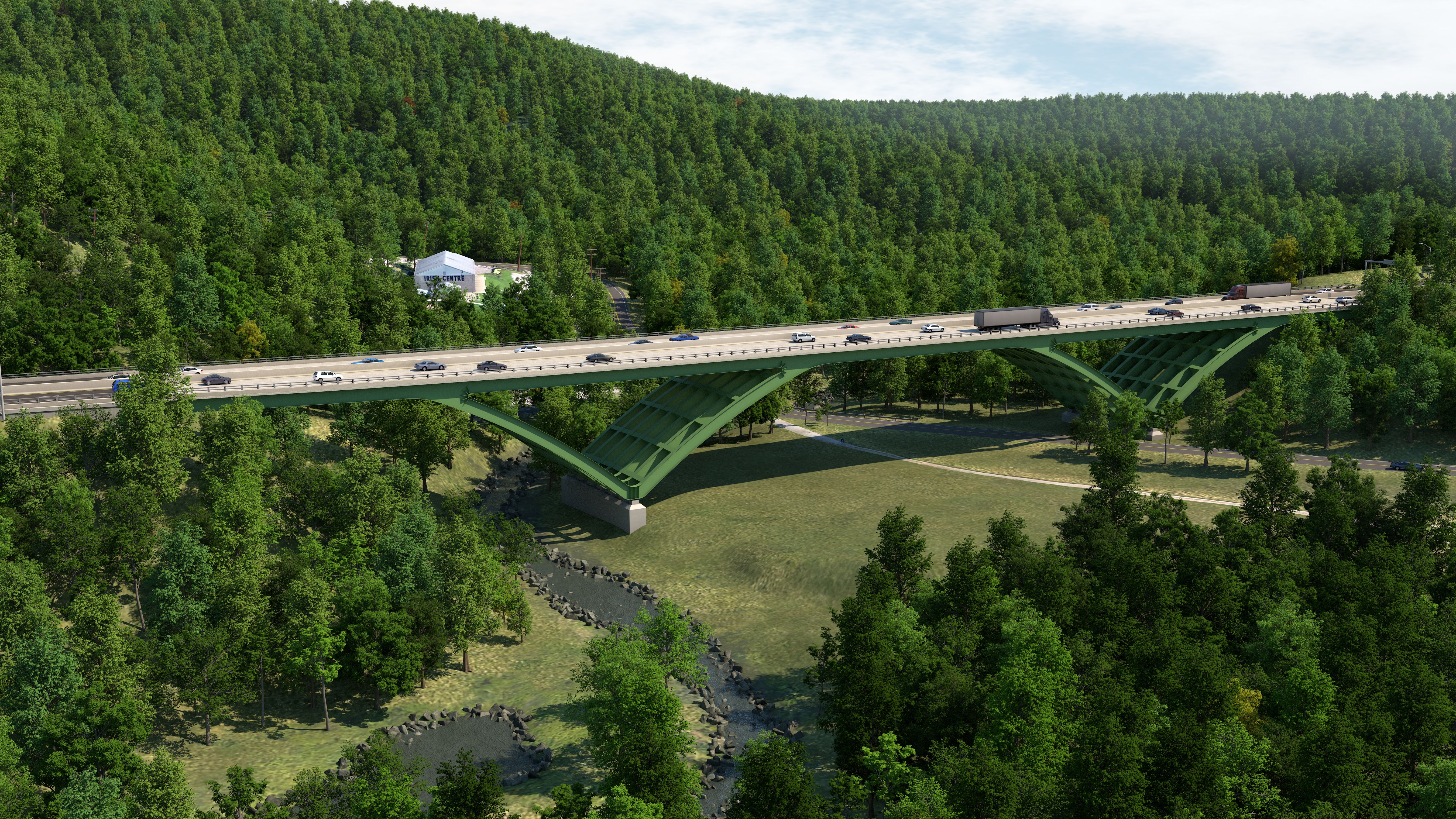Green arched bridge with multiple vehicles crossing, surrounded by dense forest and a small river flowing below under a partly cloudy sky.