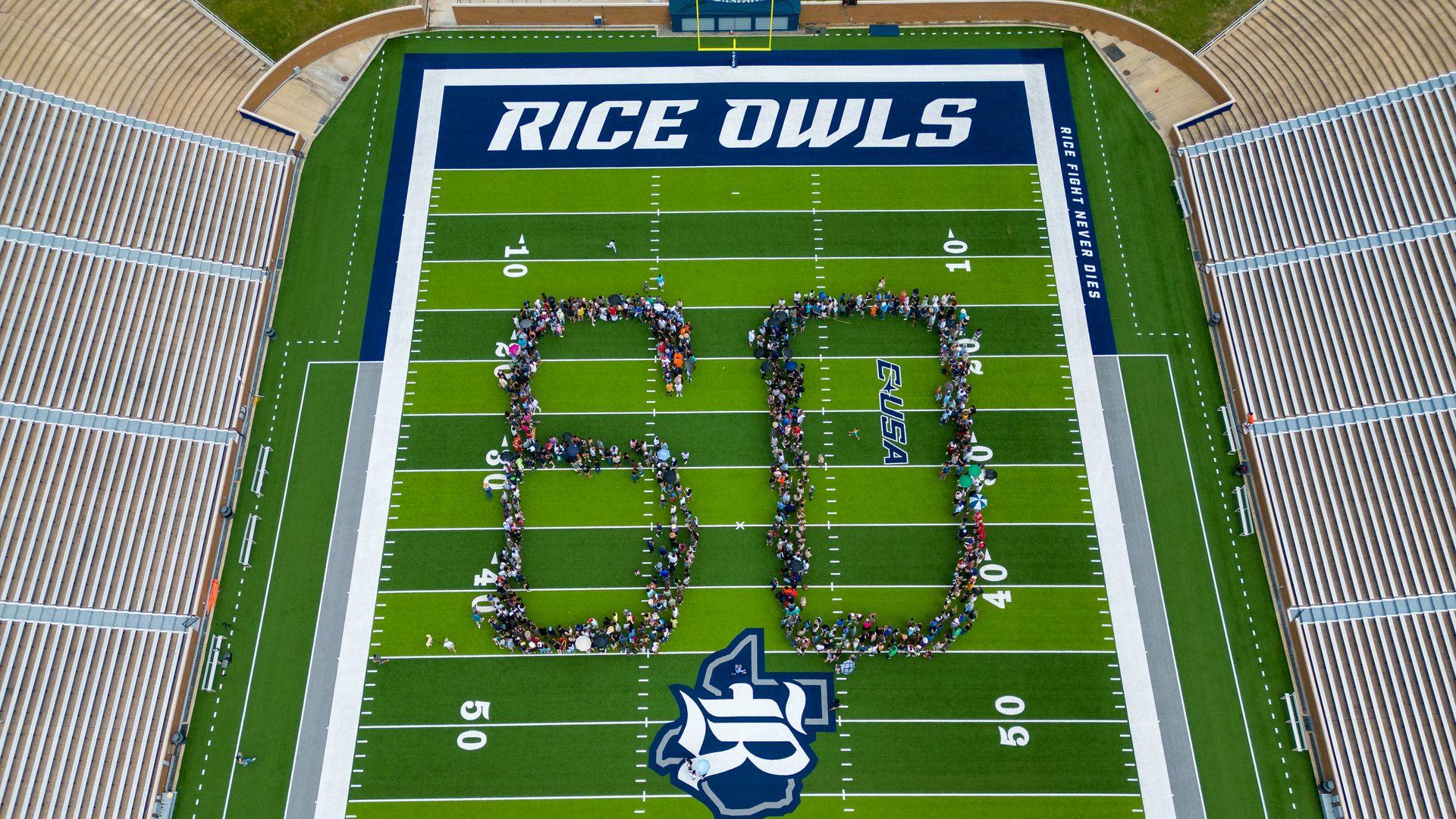 Photo of hundreds of people formed in a  shape of the number "60" at Rice stadium. 