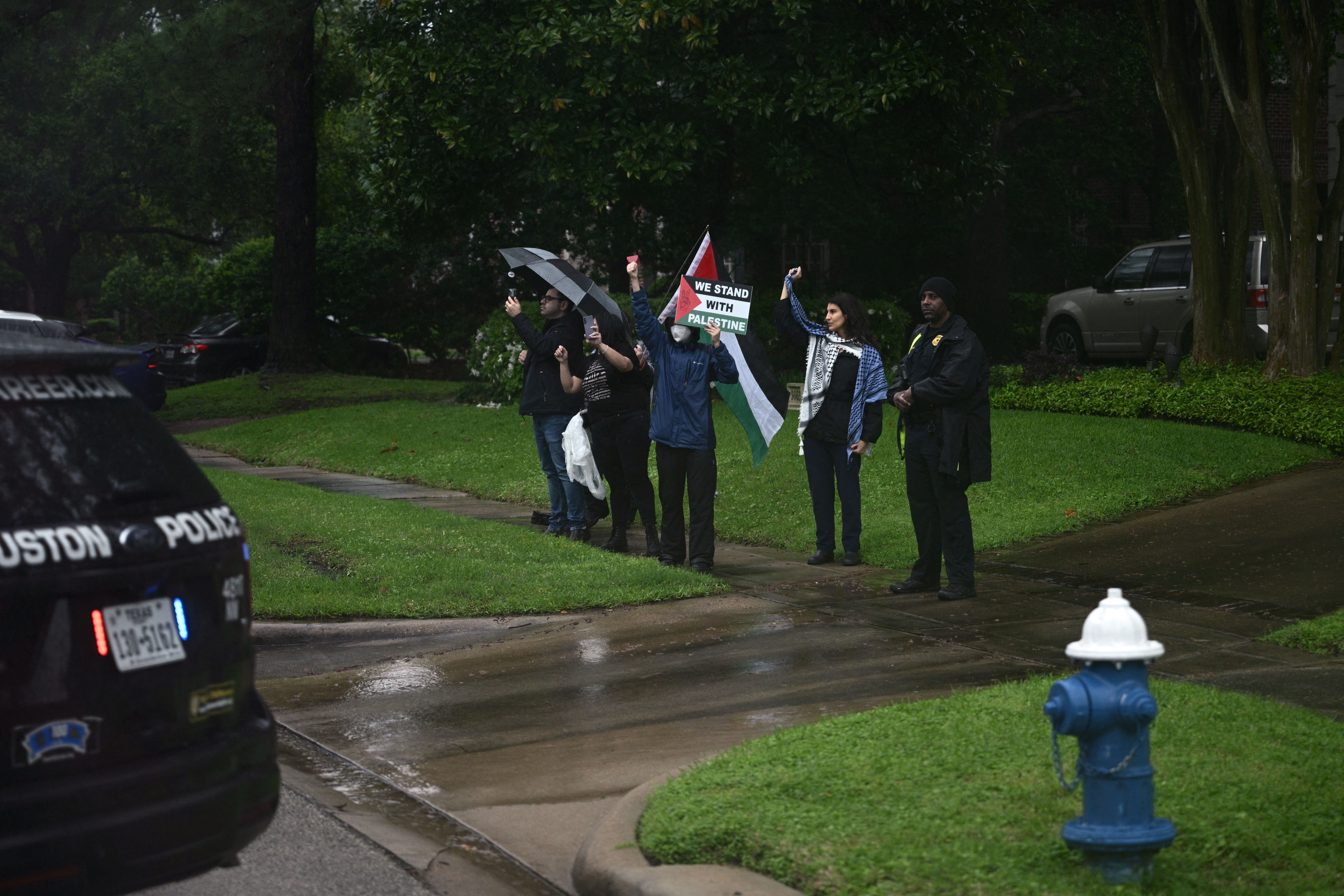 Protesters demonstrate on a sidewalk in the rain