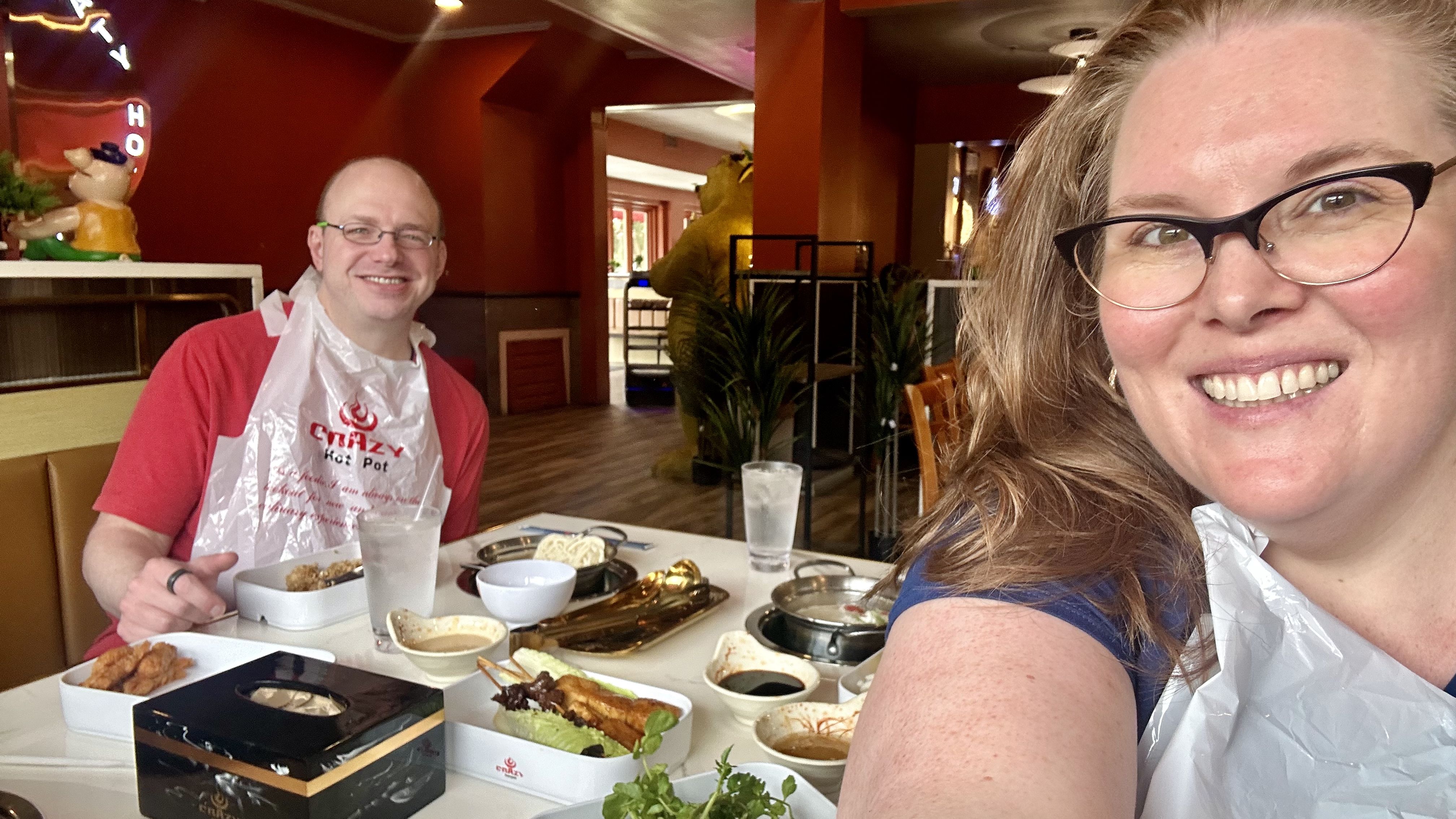 Photo shows Carlie and her husband Caleb smiling at a table while eating hot pot in Metairie.