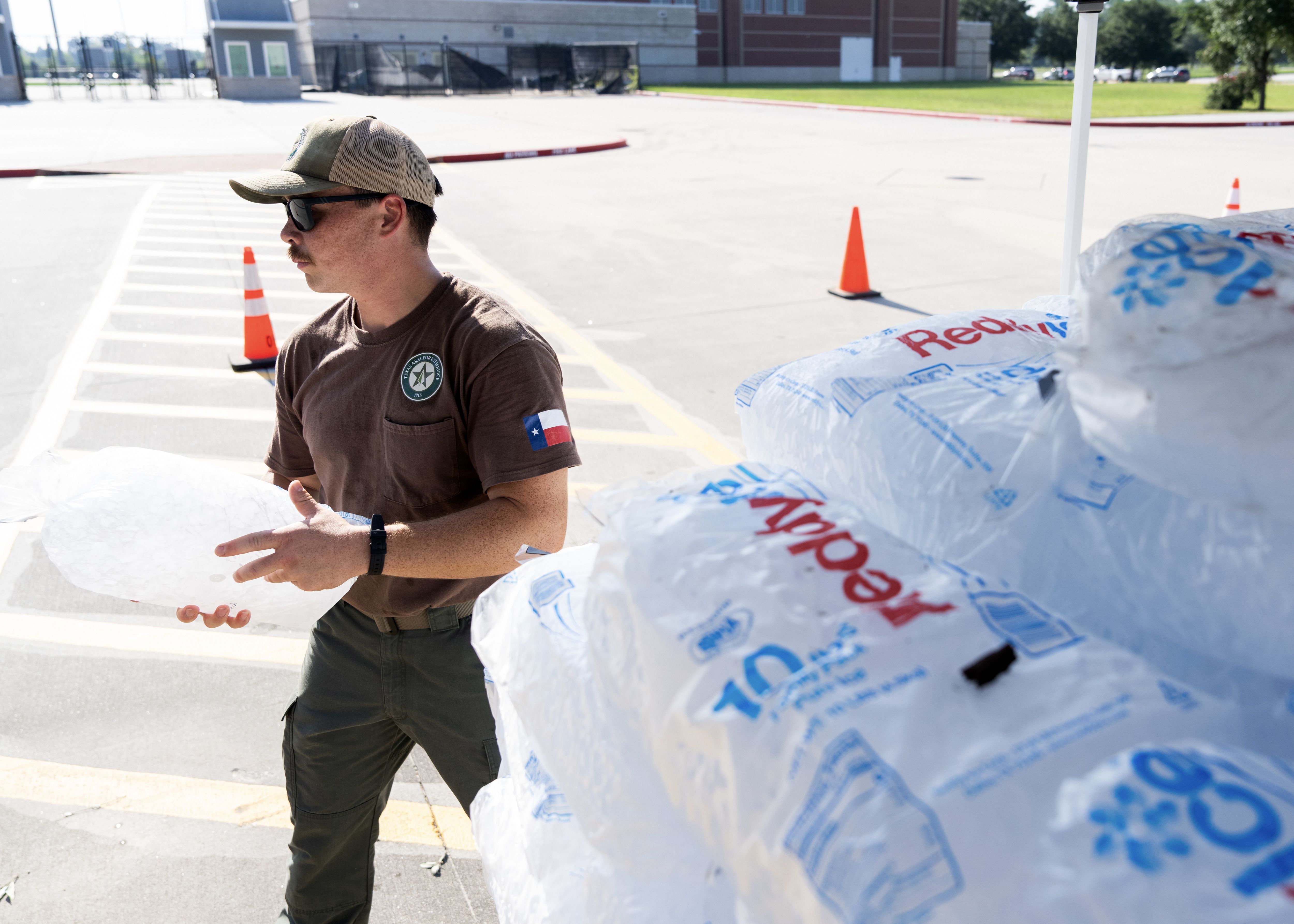 ugust Lenarz with the Texas A&M Fire Service, holds a bag of ice during a supply distribution at Woodforest Bank Stadium after Hurricane Beryl made its way through the Greater Houston area, Wednesday, July 10, 2024, in Shenandoah. 