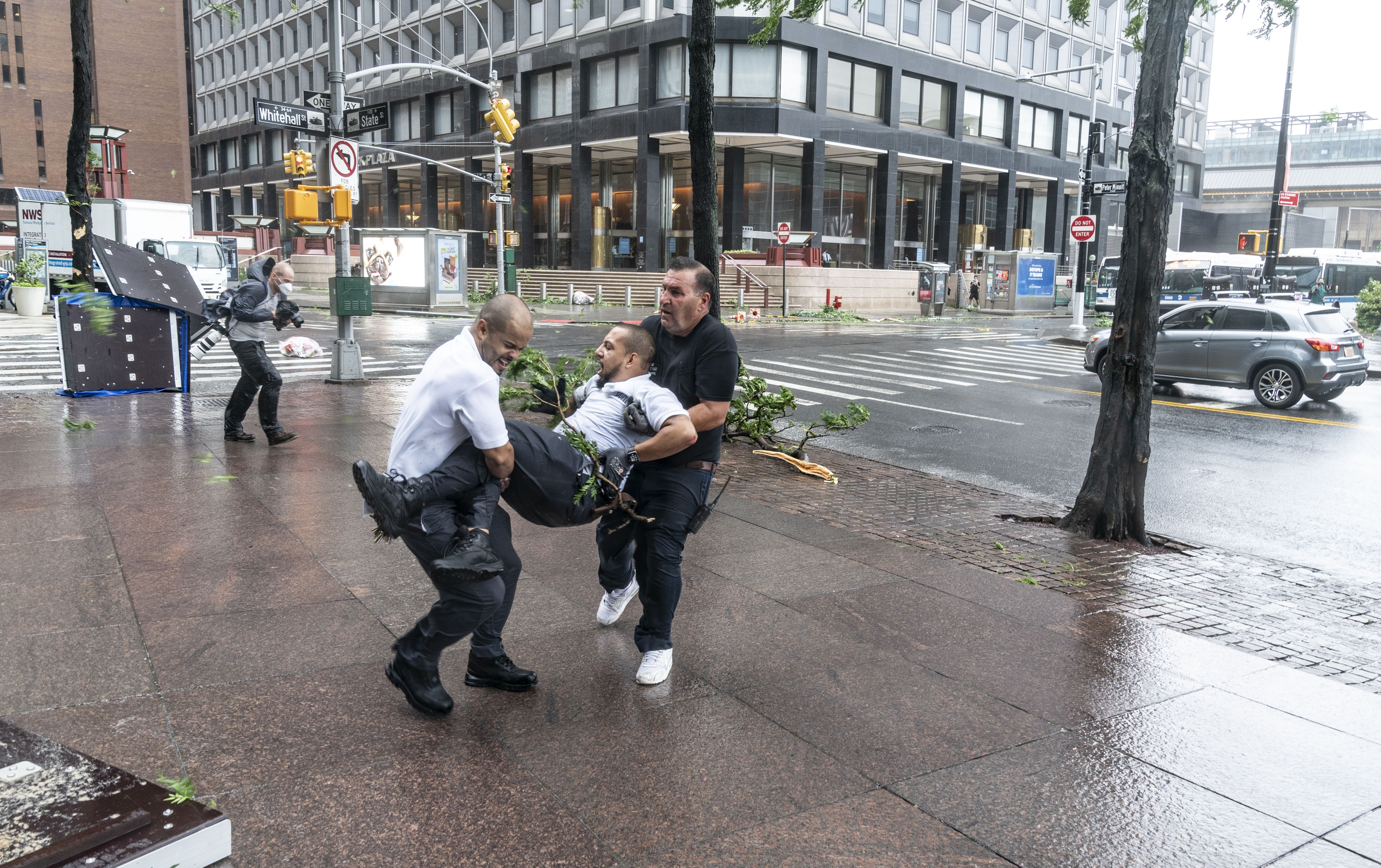 Co-workers cary injured maintenance worker by downed by strong wind tree after tropical storm Isaias lashes out New York City as seen in lower Manhattan, New York, United States on August 04