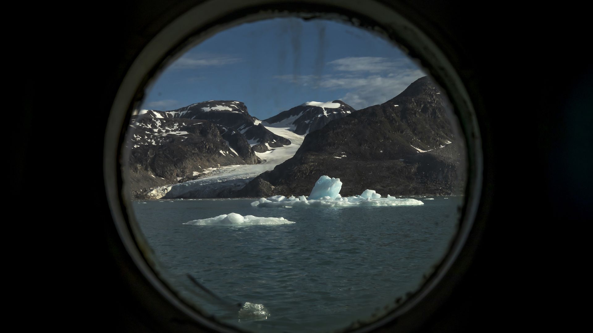 The Svalbard Islands, in Norway, viewed through a porthole of a ship in the Arctic Ocean in July 2022.