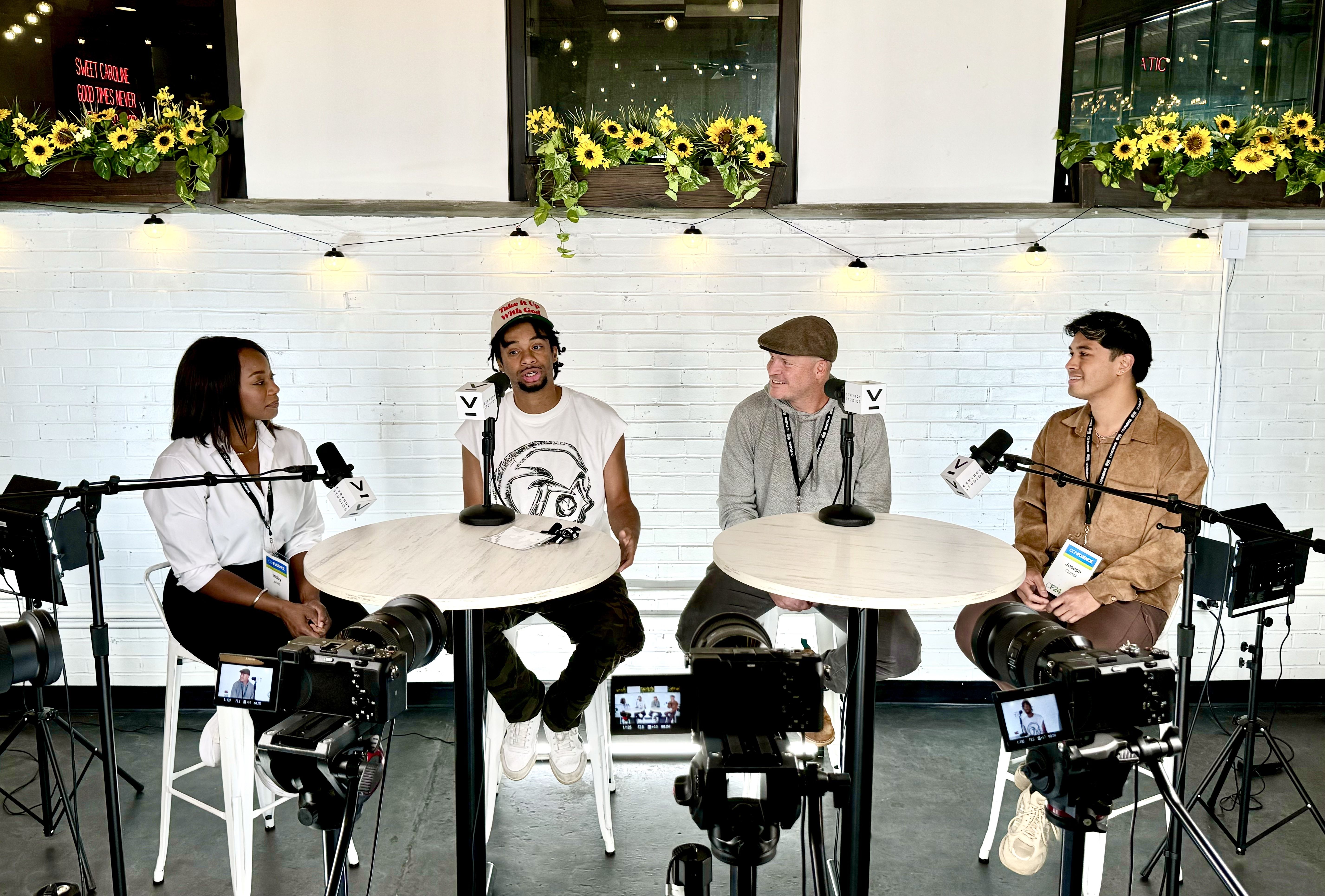 four people talking into microphones