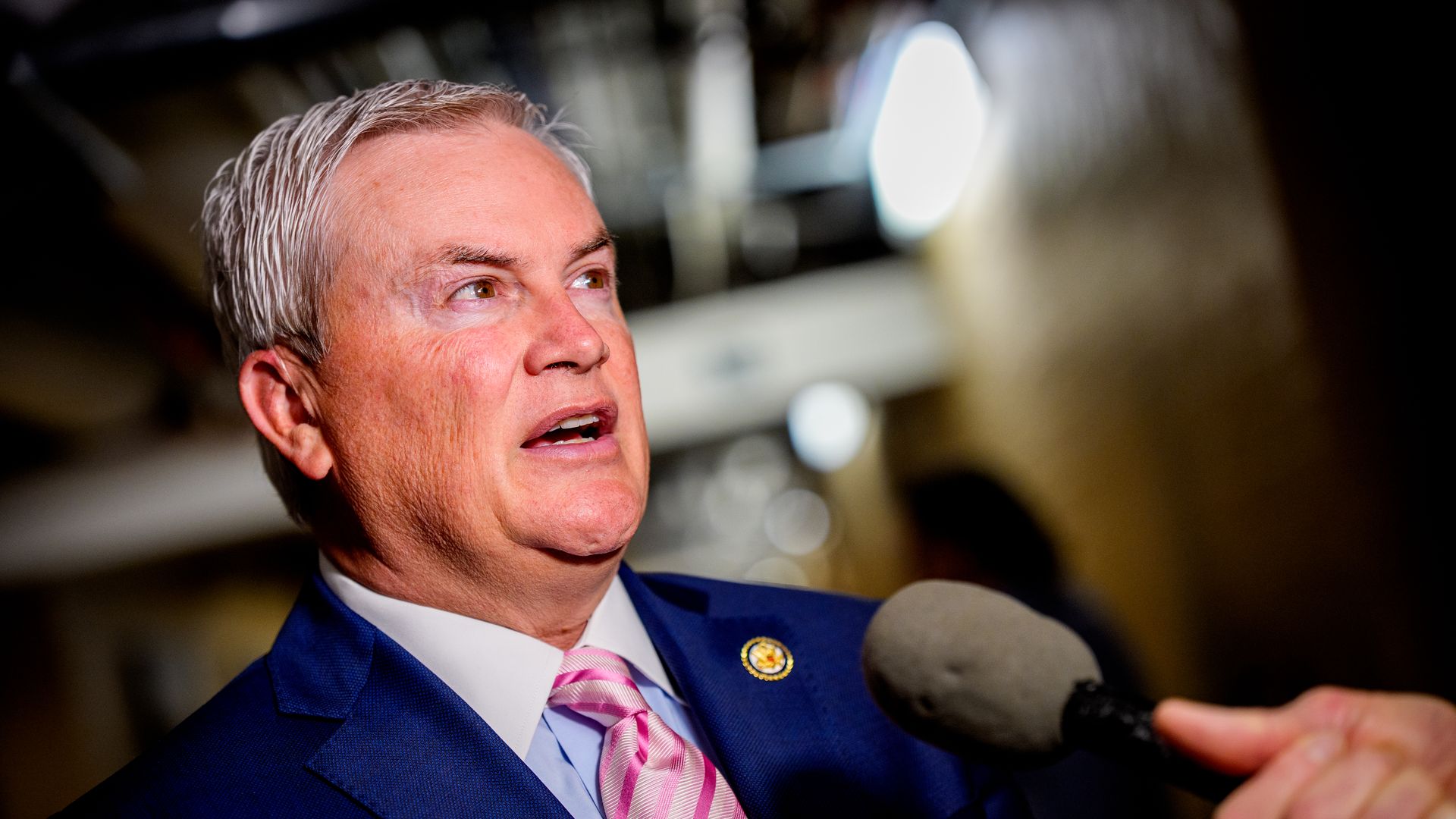 Oversight Chairman James Comer, wearing a blue suit and pink tie, speaks to a reporter at the US Capitol in May 