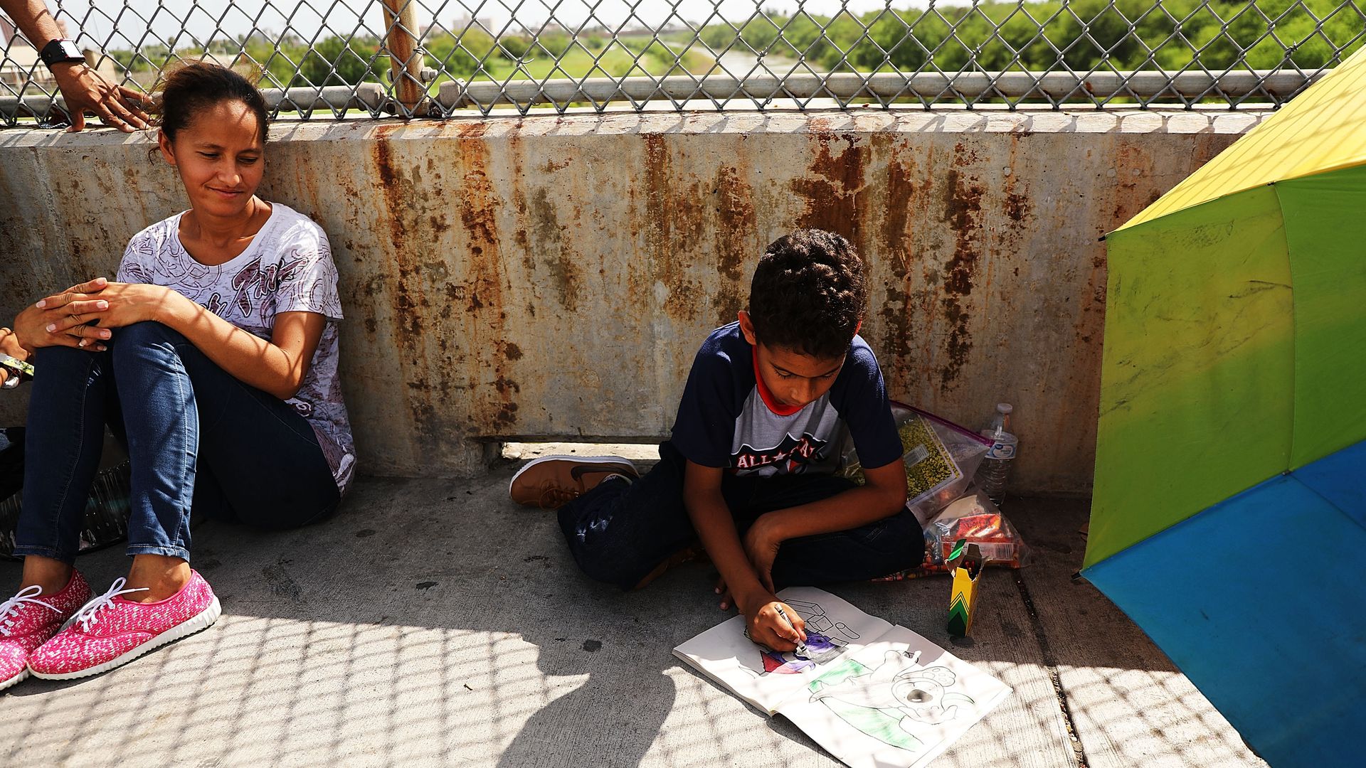 A migrant child coloring along the US-Mexico border