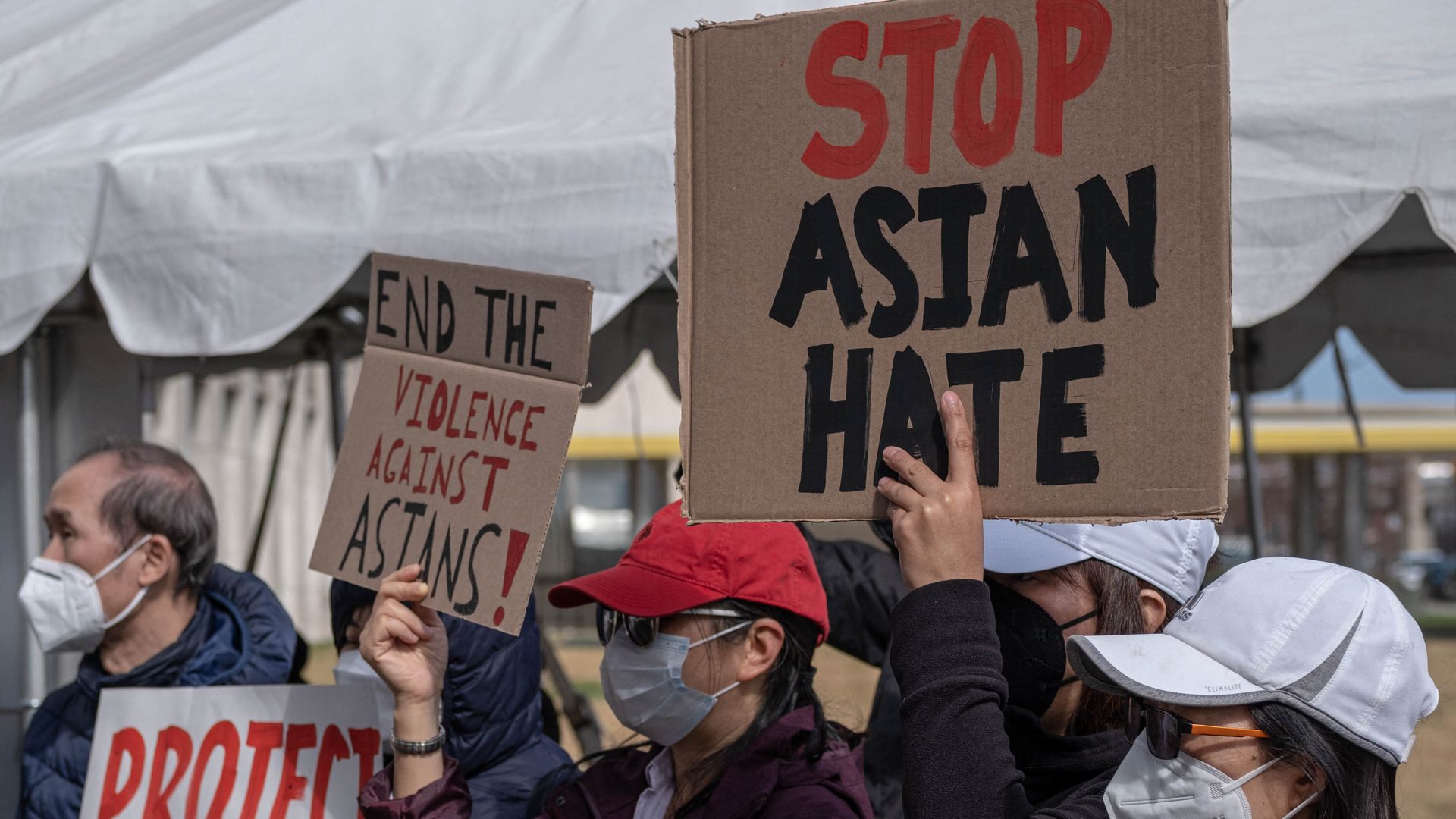 Picture of people holding signs that say "stop asian hate"