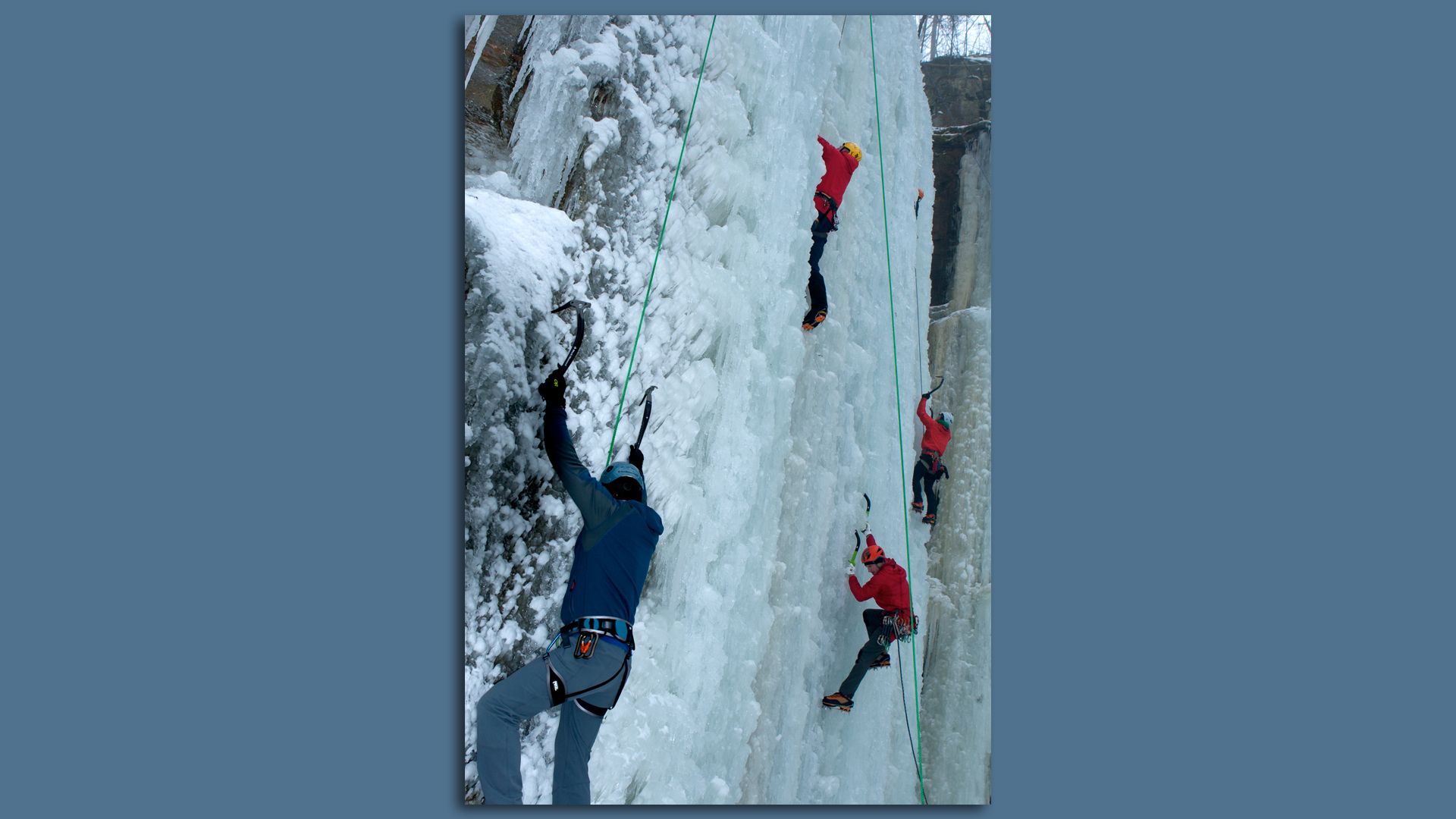 people ice climbing with axes on a frozen water formation in sandstone mn