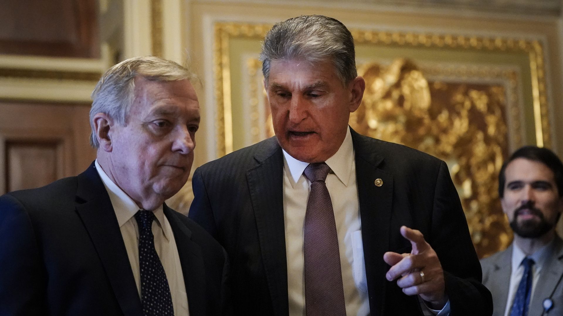 Sens. Dick Durbin and Joe Manchin, both wearing gray suits and white shirts, in the Senate side of the Capitol.