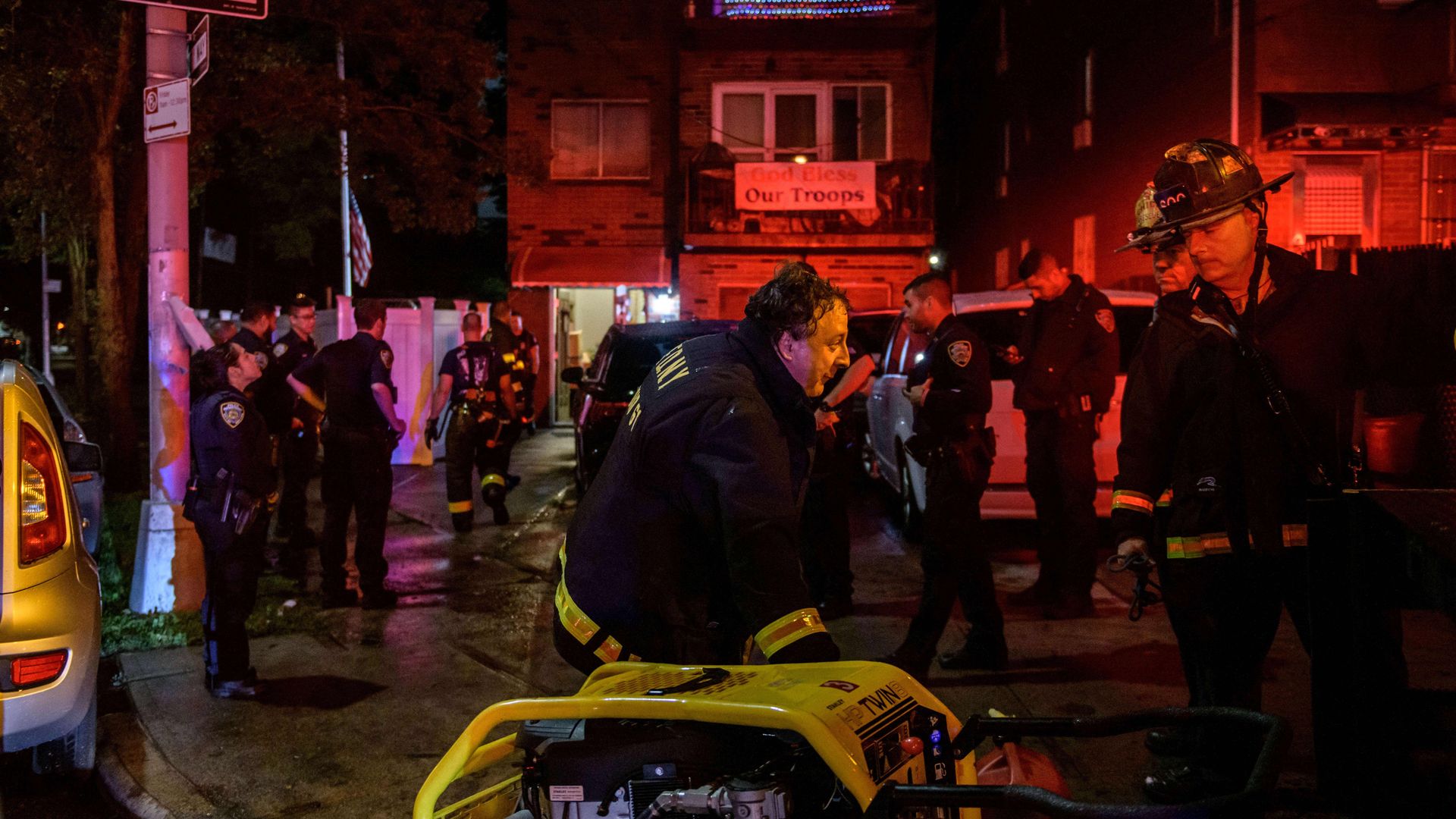 Police officers and rescue workers gather outside a house where a person was trapped in a flooded basement in Queens, New York early on September 2, 2021
