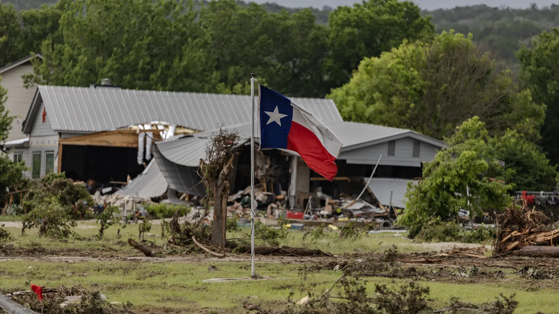 Photo of a Texas flag flying in the aftermath of floods