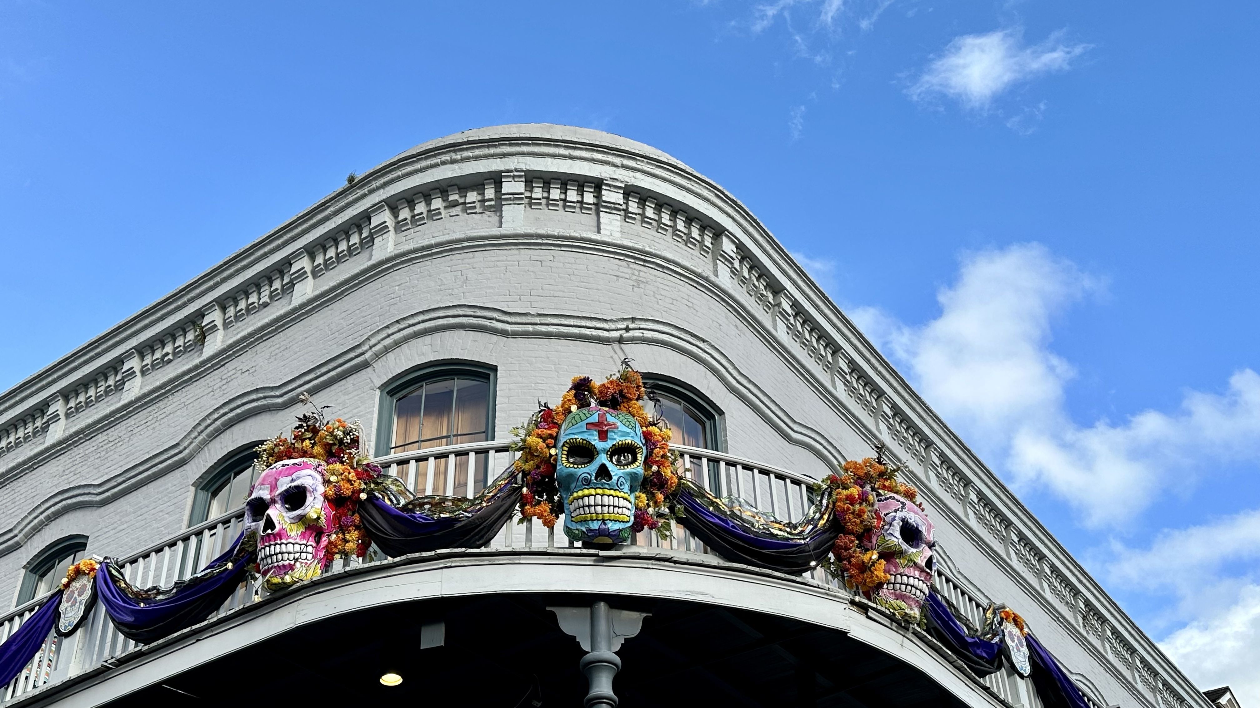 Photo shows Day of the Dead skulls on the balcony of a French Quarter building