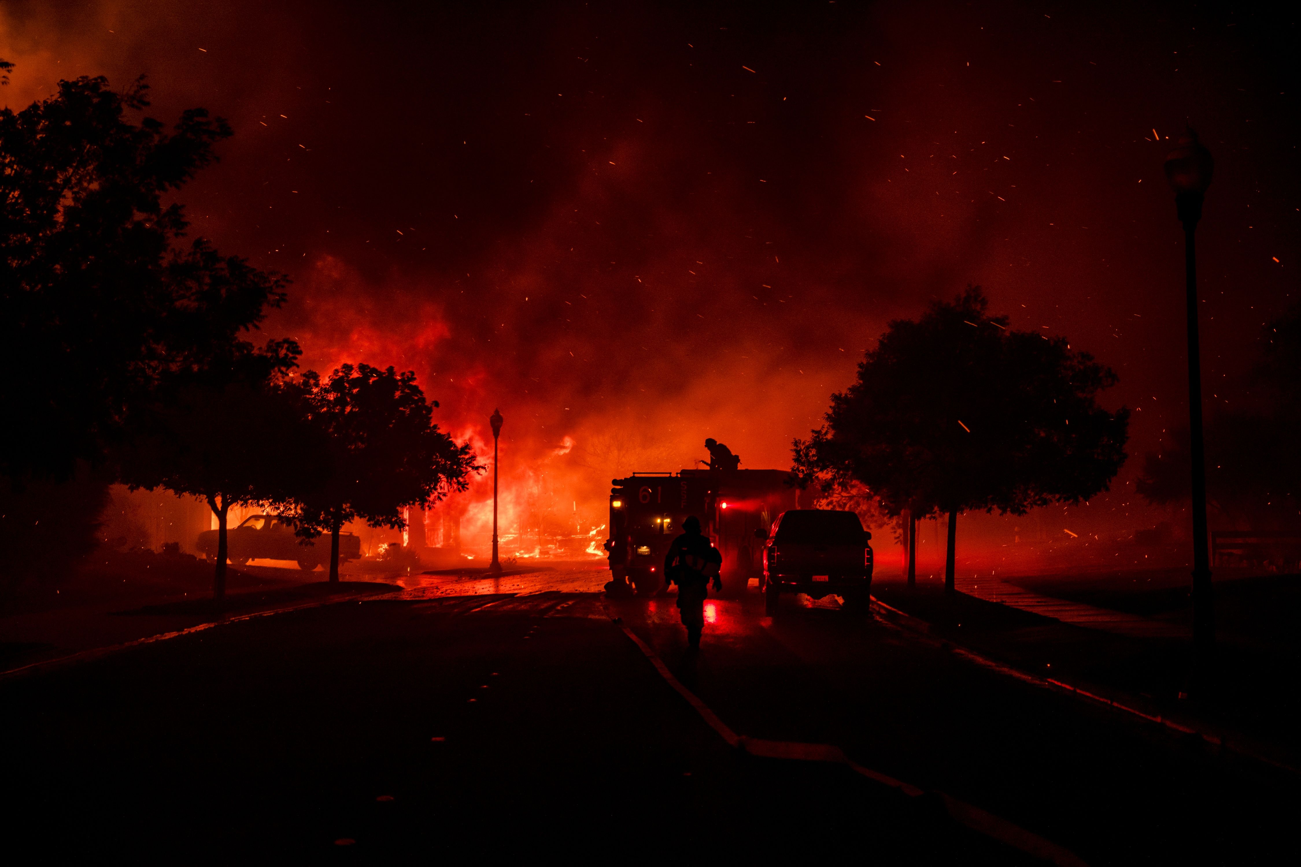 Firefighters intervene while a home bursts into flames from the Shady Fire as it approaches Santa Rosa, on September 28