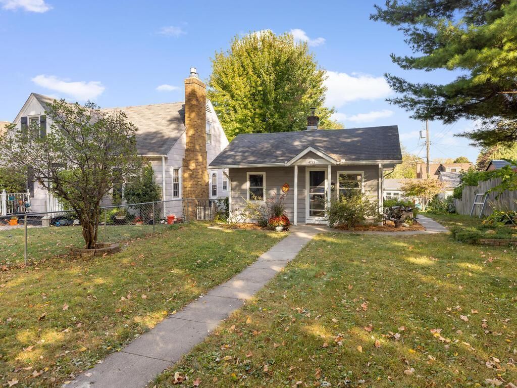 A small gray house on a grassy lot.