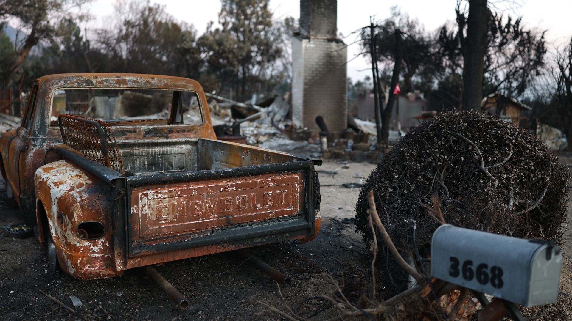Photo of a burned out home and pickup truck from a wildfire in California. 