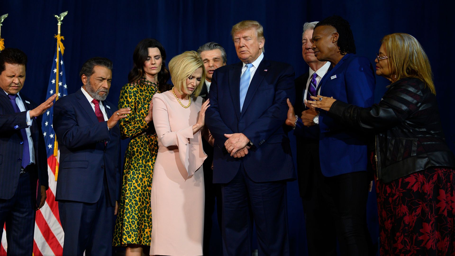 President Trump stands in a prayer circle with faith leaders