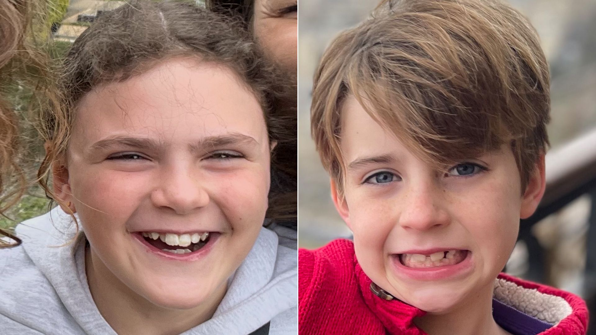 Close-up of two children side by side, one girl with curly brown hair in a gray hoodie laughing, and one boy with light brown hair in a red jacket making a playful grimace.