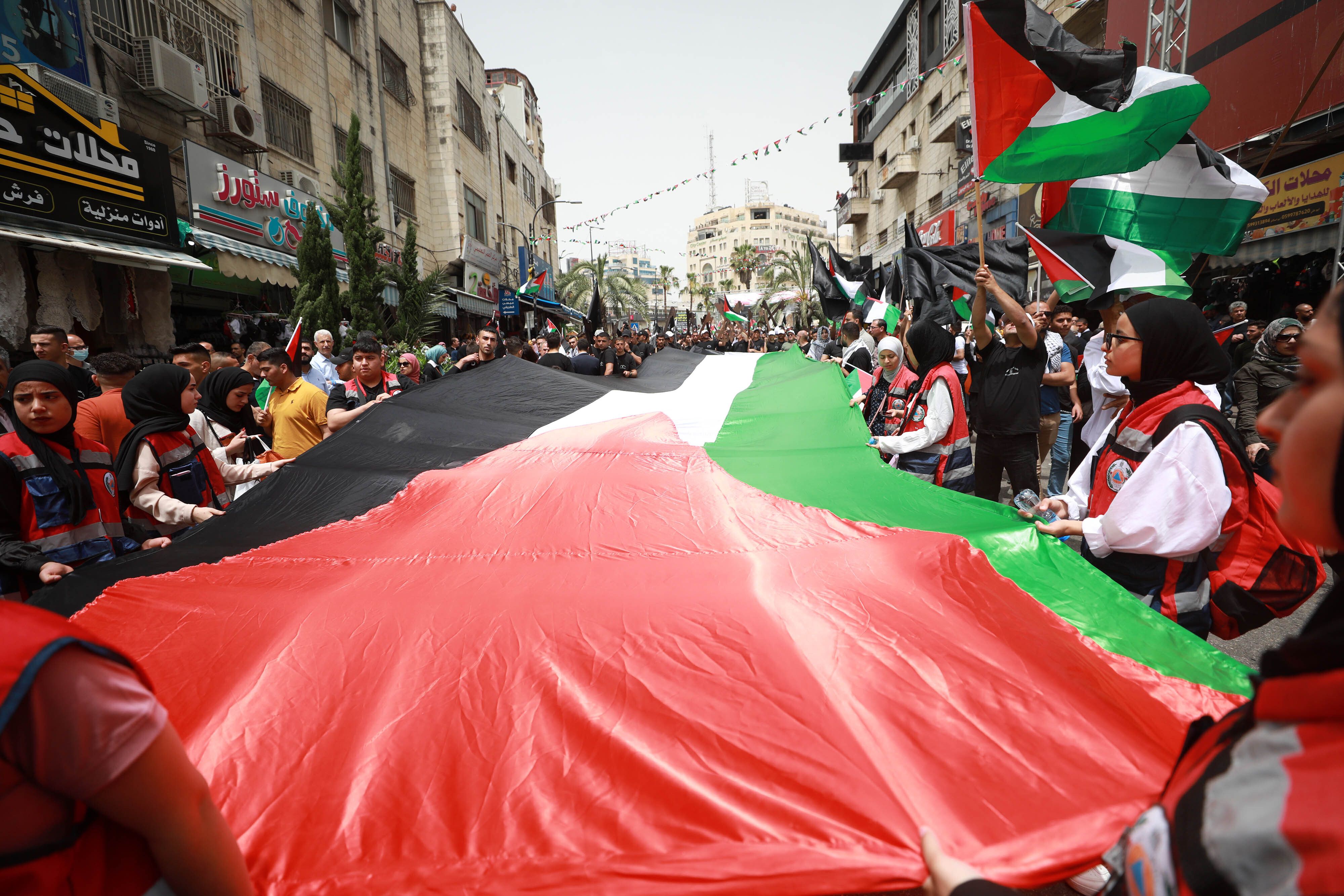 People take part in a demonstration with Palestinian flags and banners on the 74th anniversary of the Nakba, in Ramallah, West Bank on May 15, 2022. 