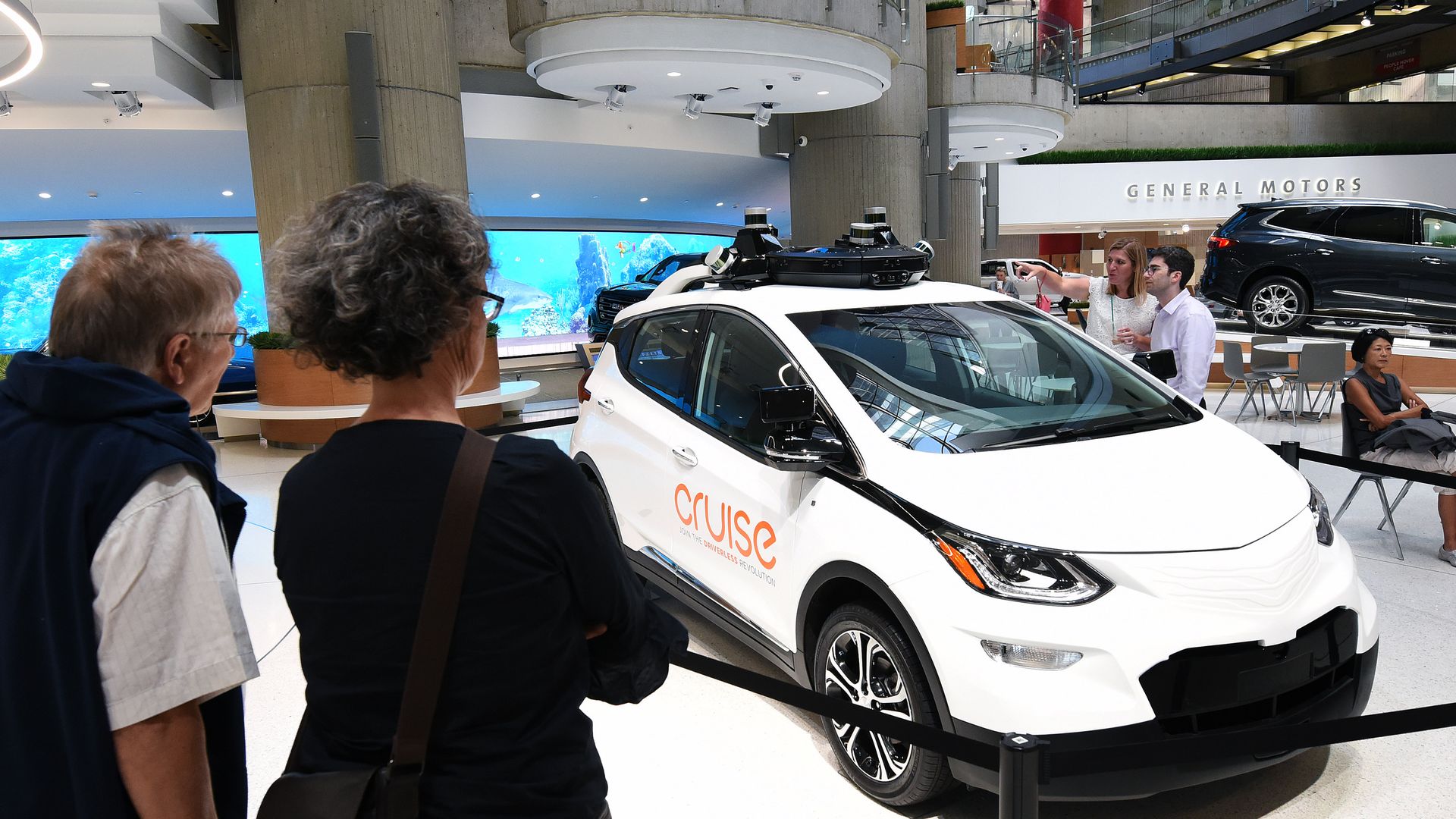 People admire a GM Cruise self-driving car on display at the General Motors world headquarters