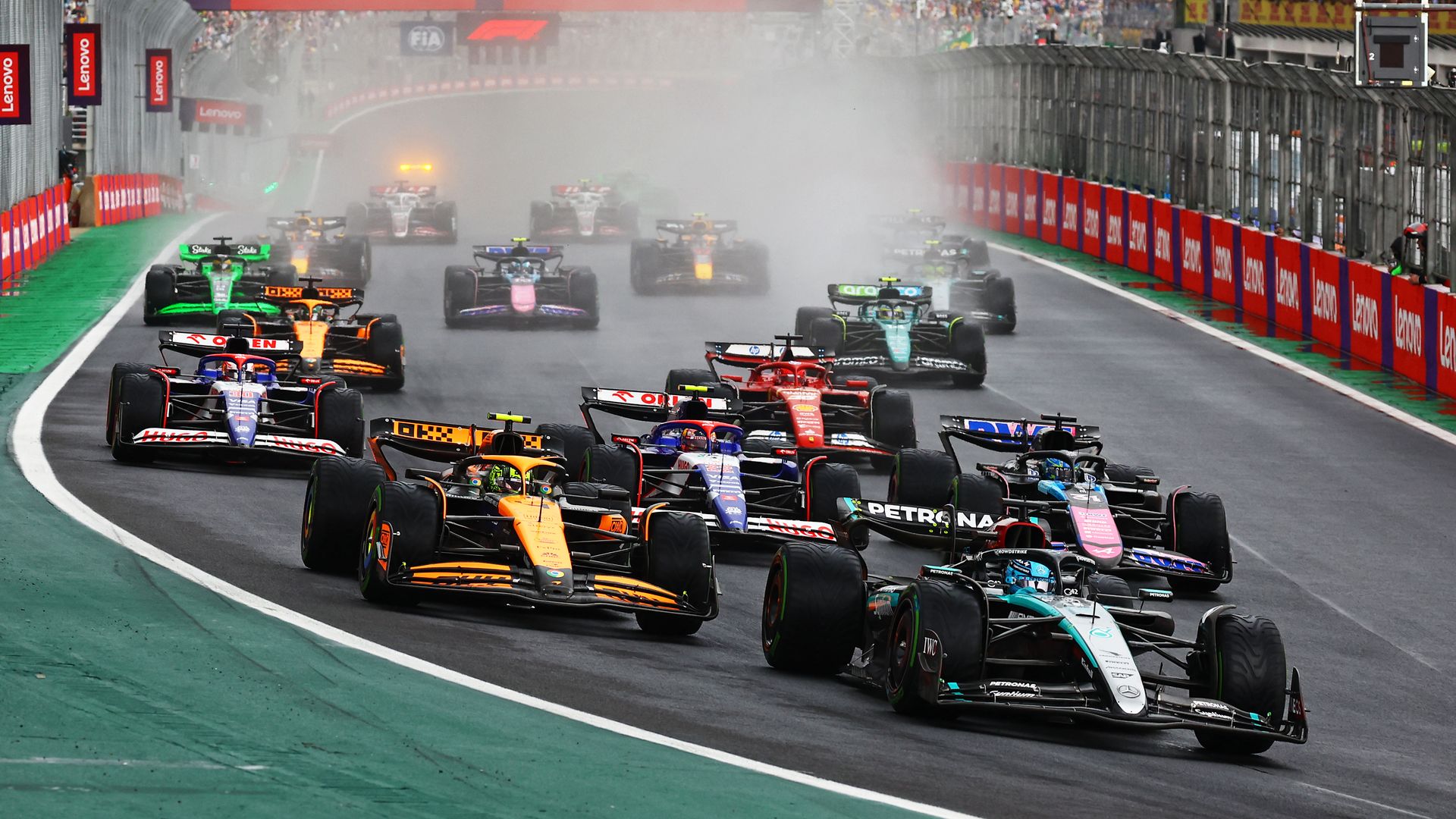 Race cars stream down a track 