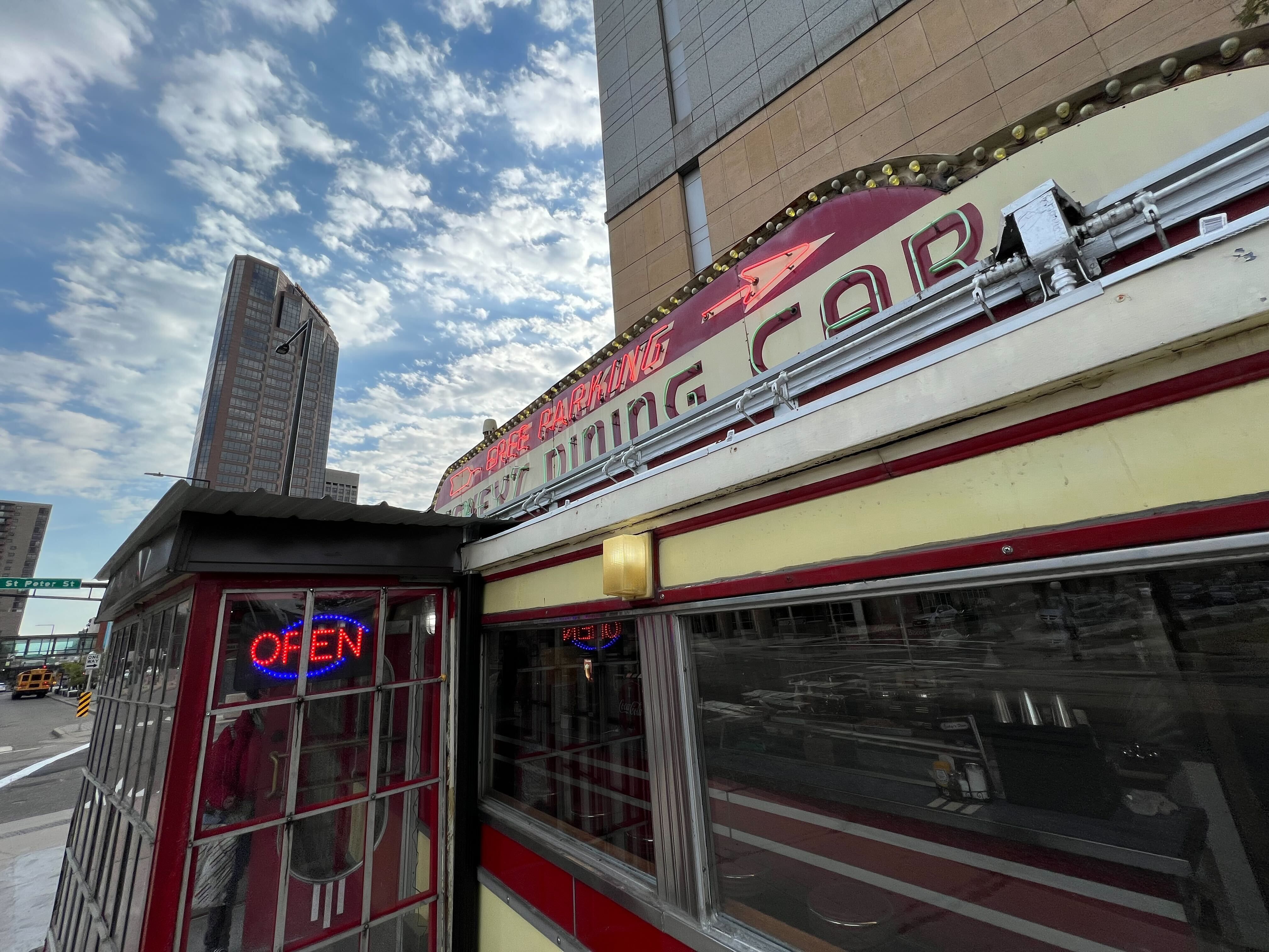 A dining car that says "Mickey's Dining Car" with an illuminated "Open" sign in the entryway
