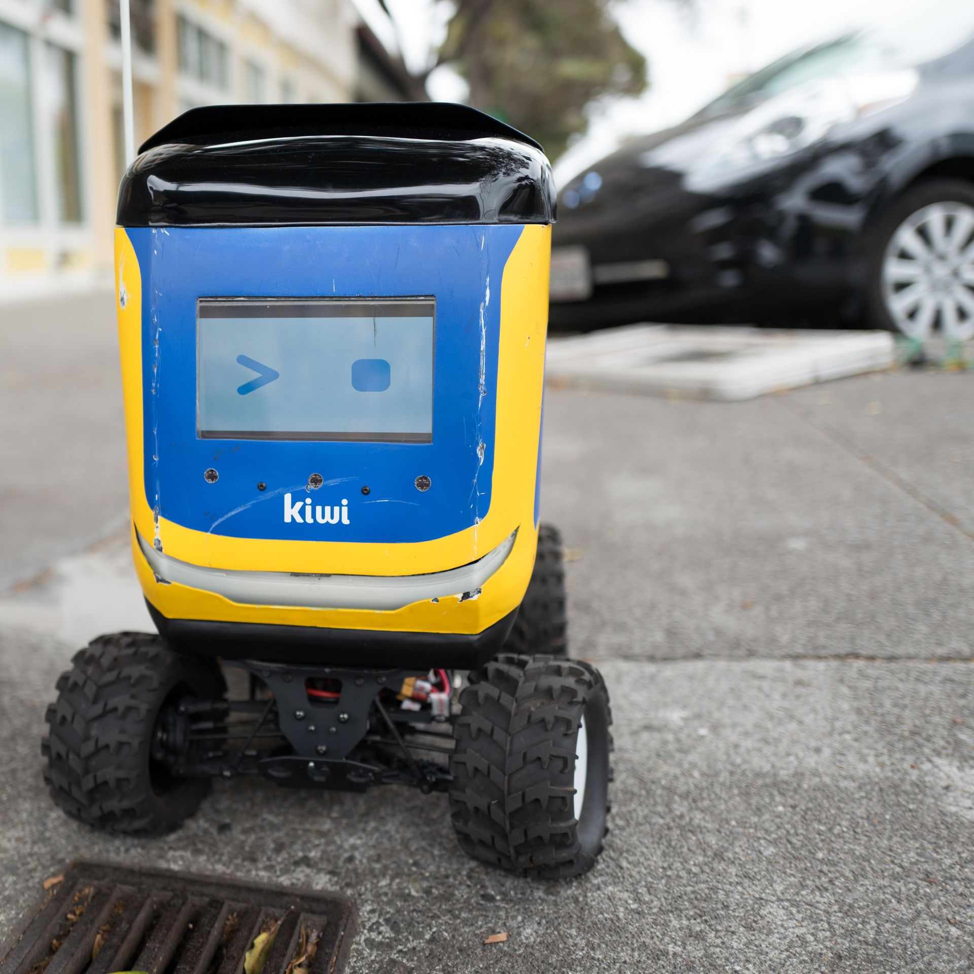 Front view with digital face of Kiwi self driving autonomous package delivery robot parked in Berkeley, California