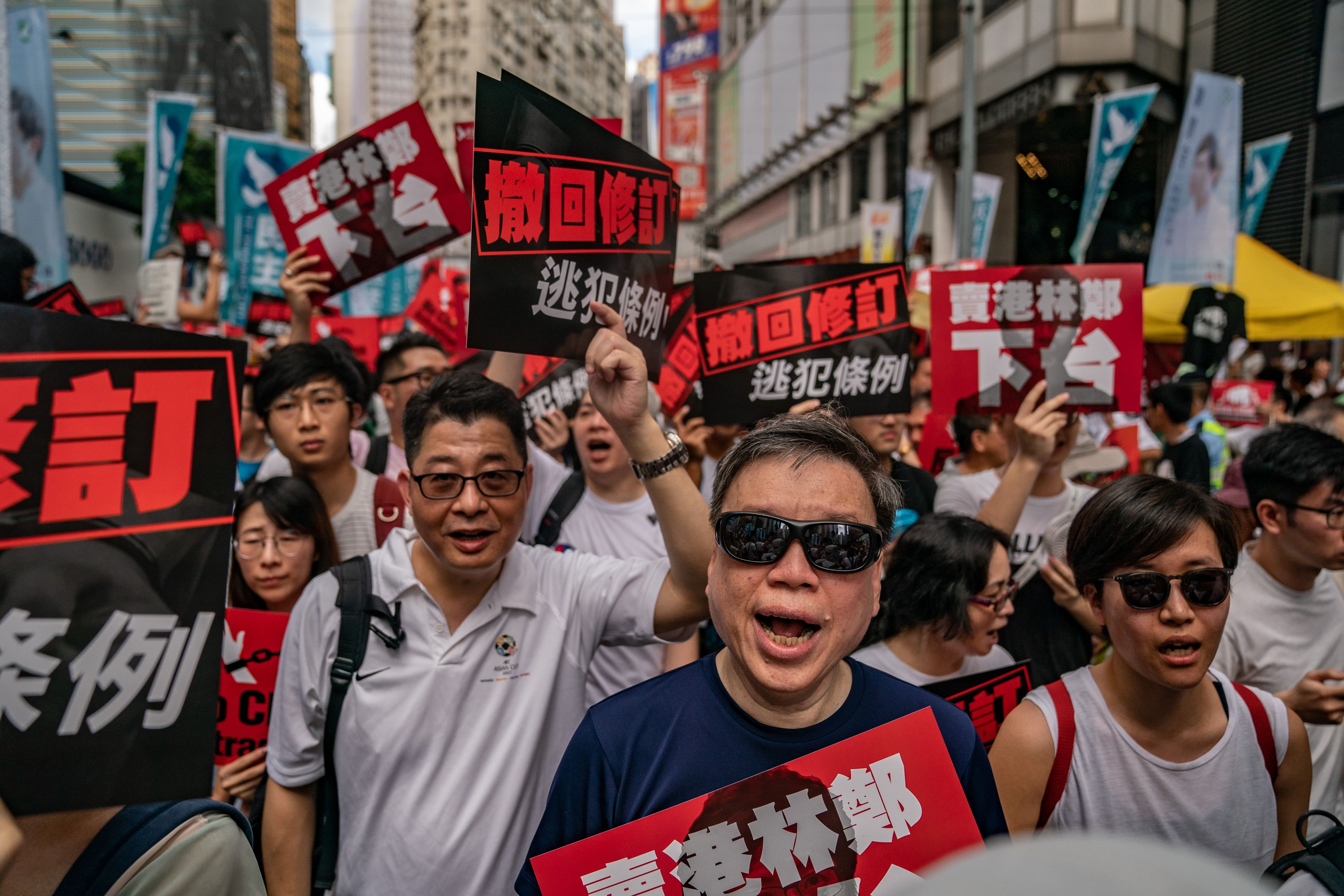 Protesters hold placards and shout slogans during a rally