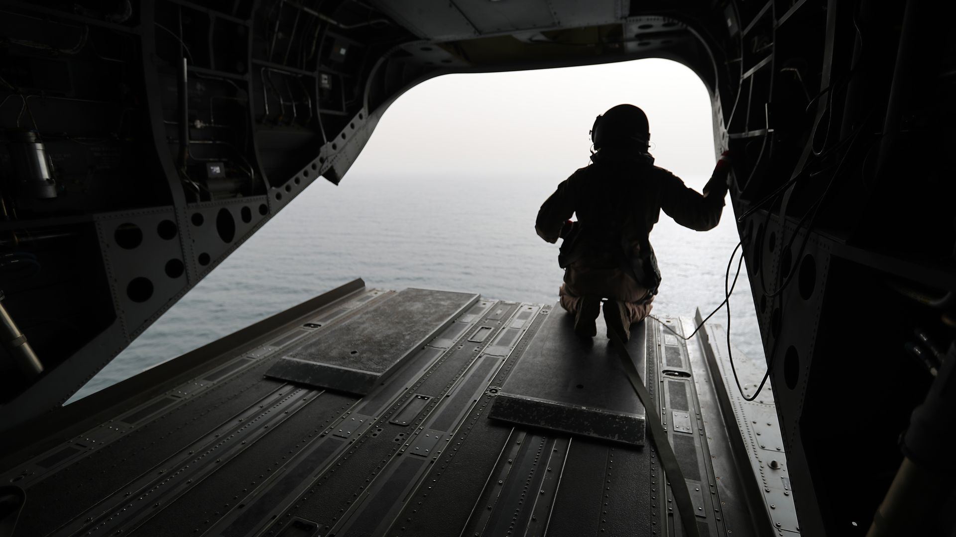 Silhouette of an Emirati soldier looking out of a military plane at the strait of Bab al-Mandab.