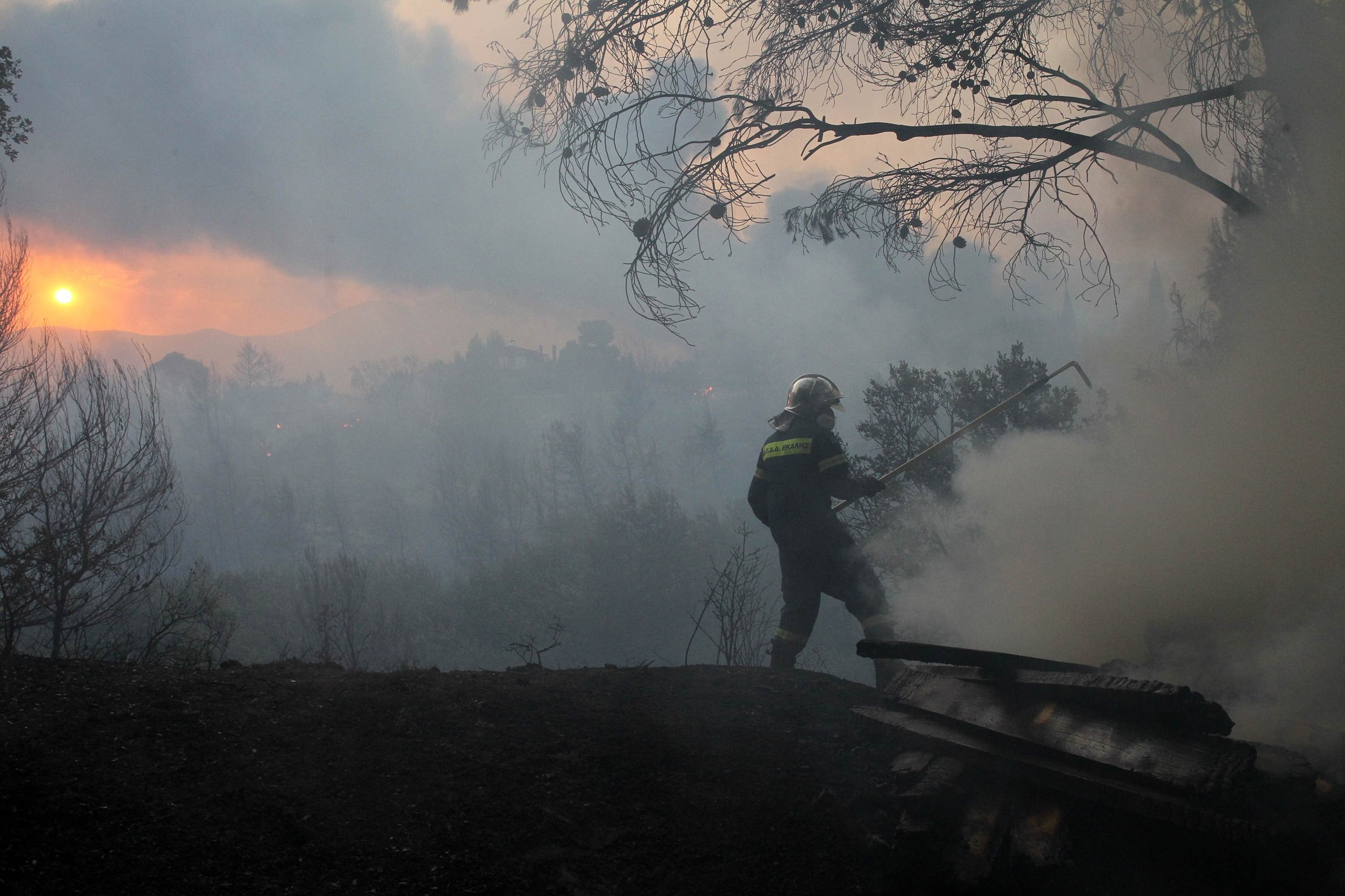 Picture of a firefighter fighting a fire, he's surrounded by smoke.