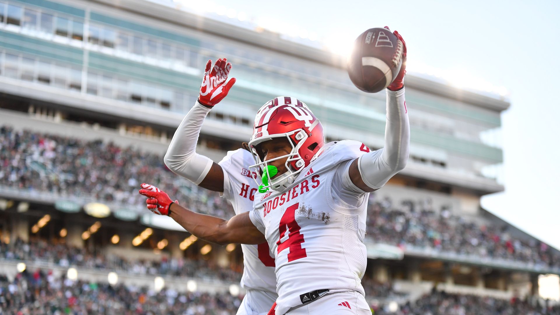 Two players in white football uniforms celebrate