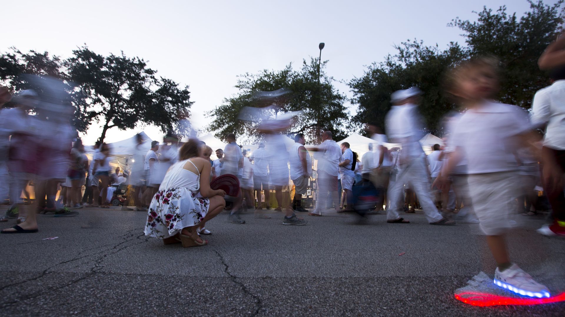 People walk around the street during White Linen Night in The Heights 