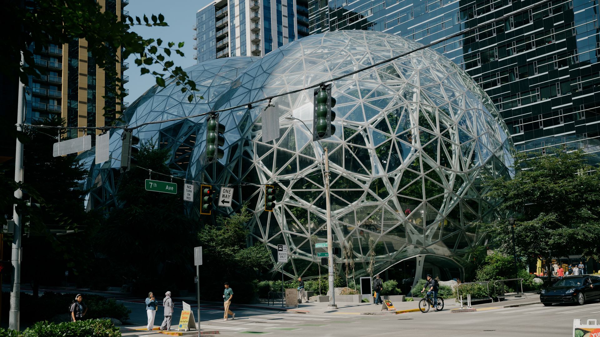 A public plaza, with two large metallic spheres and people walking around them.