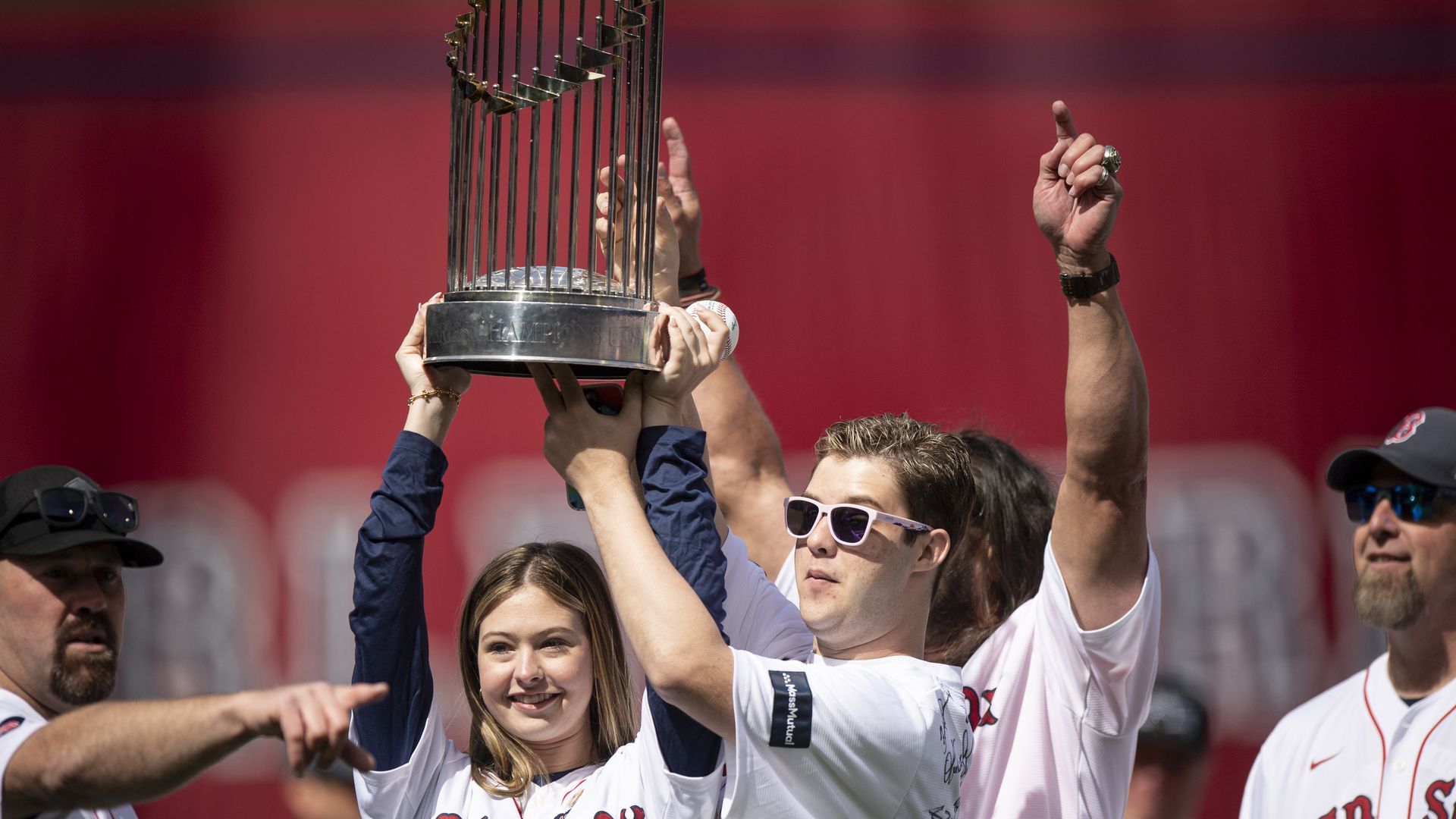 Brianna and Trevor Wakefield, son of the late former pitcher Tim Wakefield, hoist the 2004 World Series trophy during pre-game ceremonies before the 2024 Opening Day game against the Baltimore Orioles on April 9, 2024 at Fenway Park in Boston.