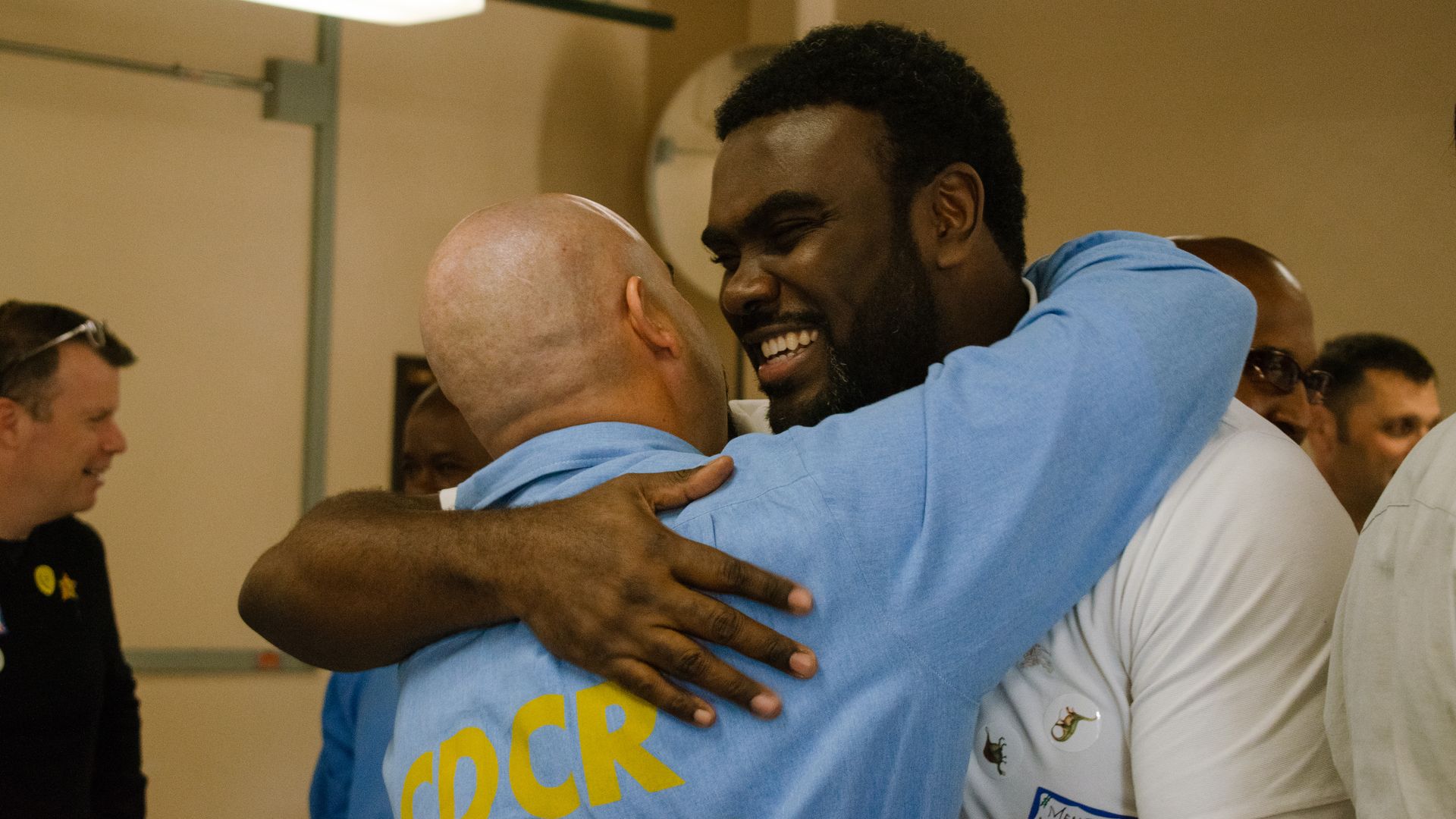 Marcus Bullock hugs a prison inmate with a big smile on his face.