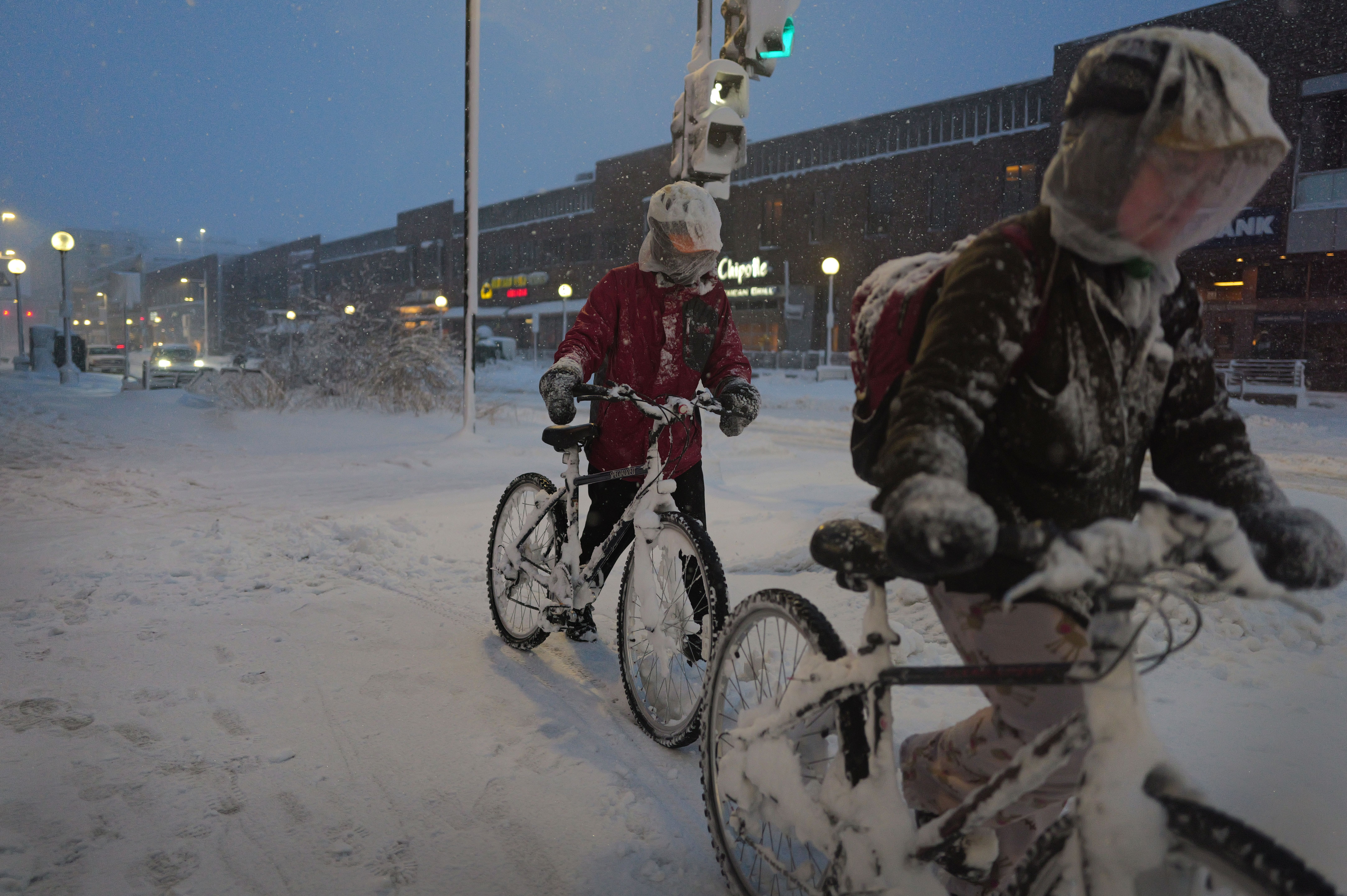 Cyclists navigate a snow-covered sidewalk on January 09, 2024 in Iowa City, Iowa. 