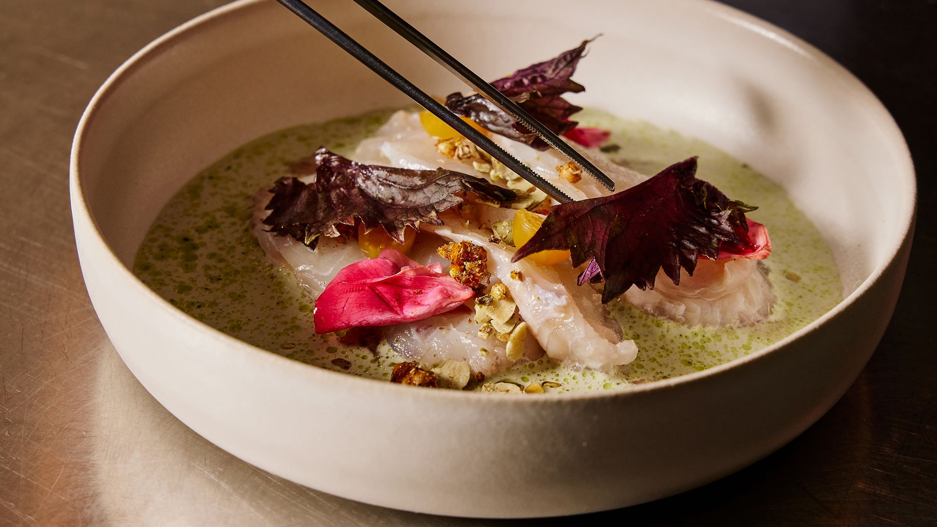 A close up of a yellowfin tuna leche de tigre dish from Urban Hearth in Cambridge. It's made with hibiscus and buttermilk, hyssop oil and pistachio.