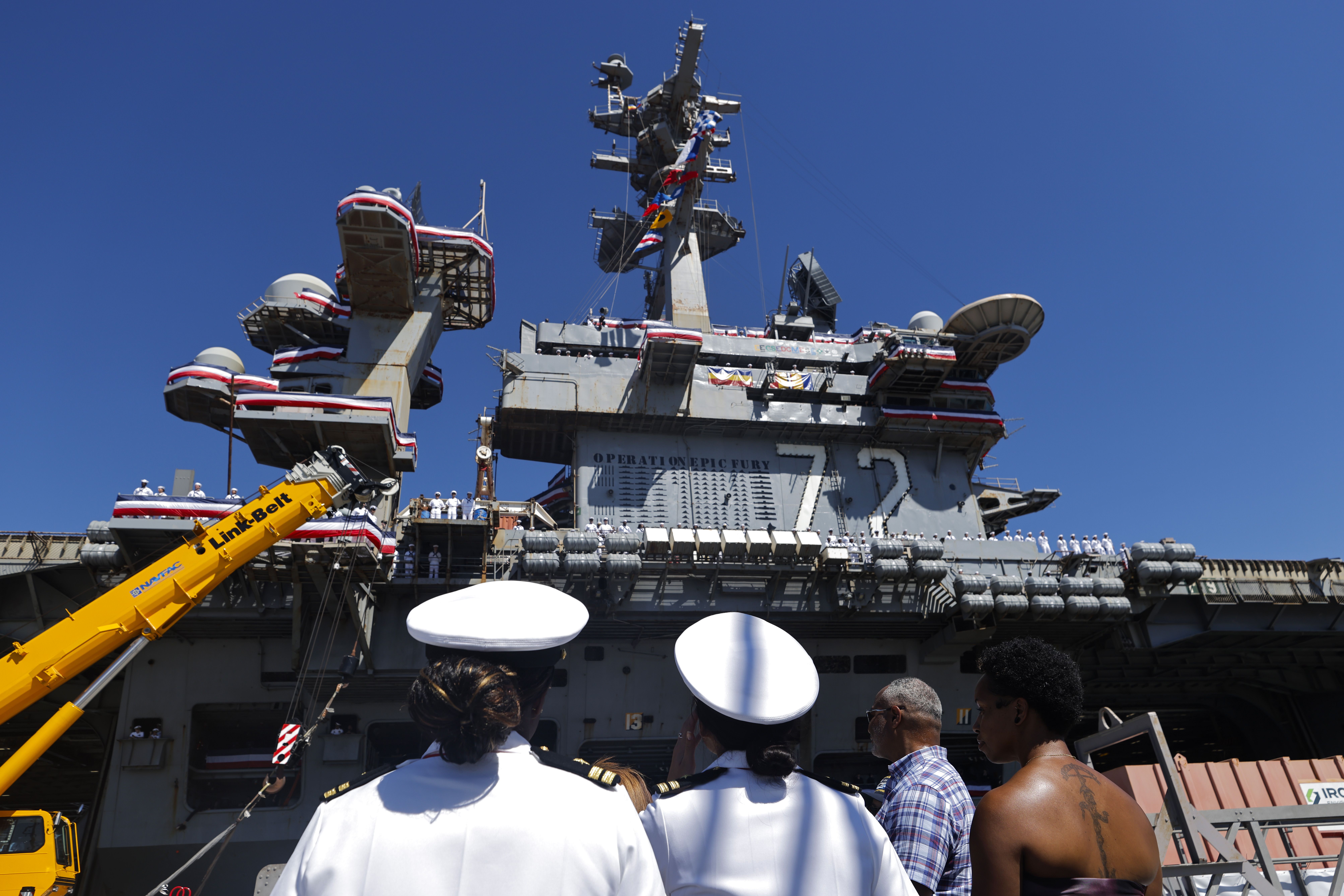 CORONADO, CALIFORNIA - OCTOBER 08: Onlookers watch as the USS Abraham Lincoln Nimitz-class aircraft carrier docks at its homeport at Naval Air Station North Island on return from its historic 10-month deployment on October 8, 2026 in Coronado, California. The USS Abraham Lincoln (CVN 72) set a U.S. 