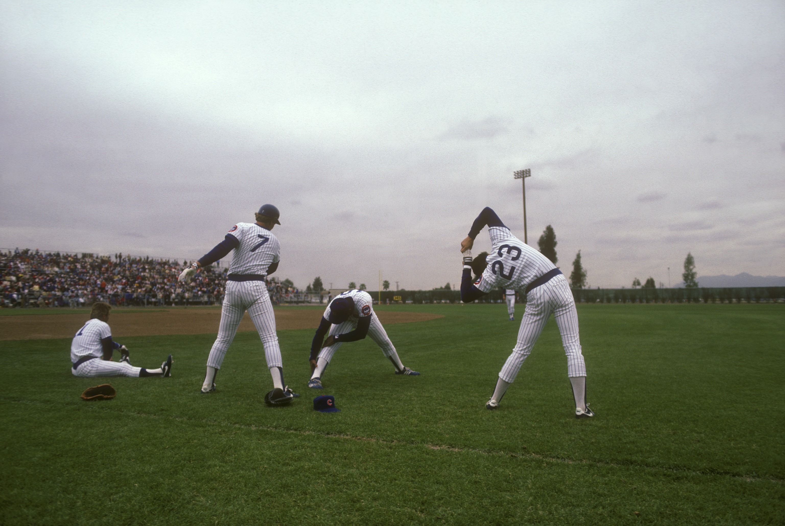 Photo of baseball players stretching on the field. 