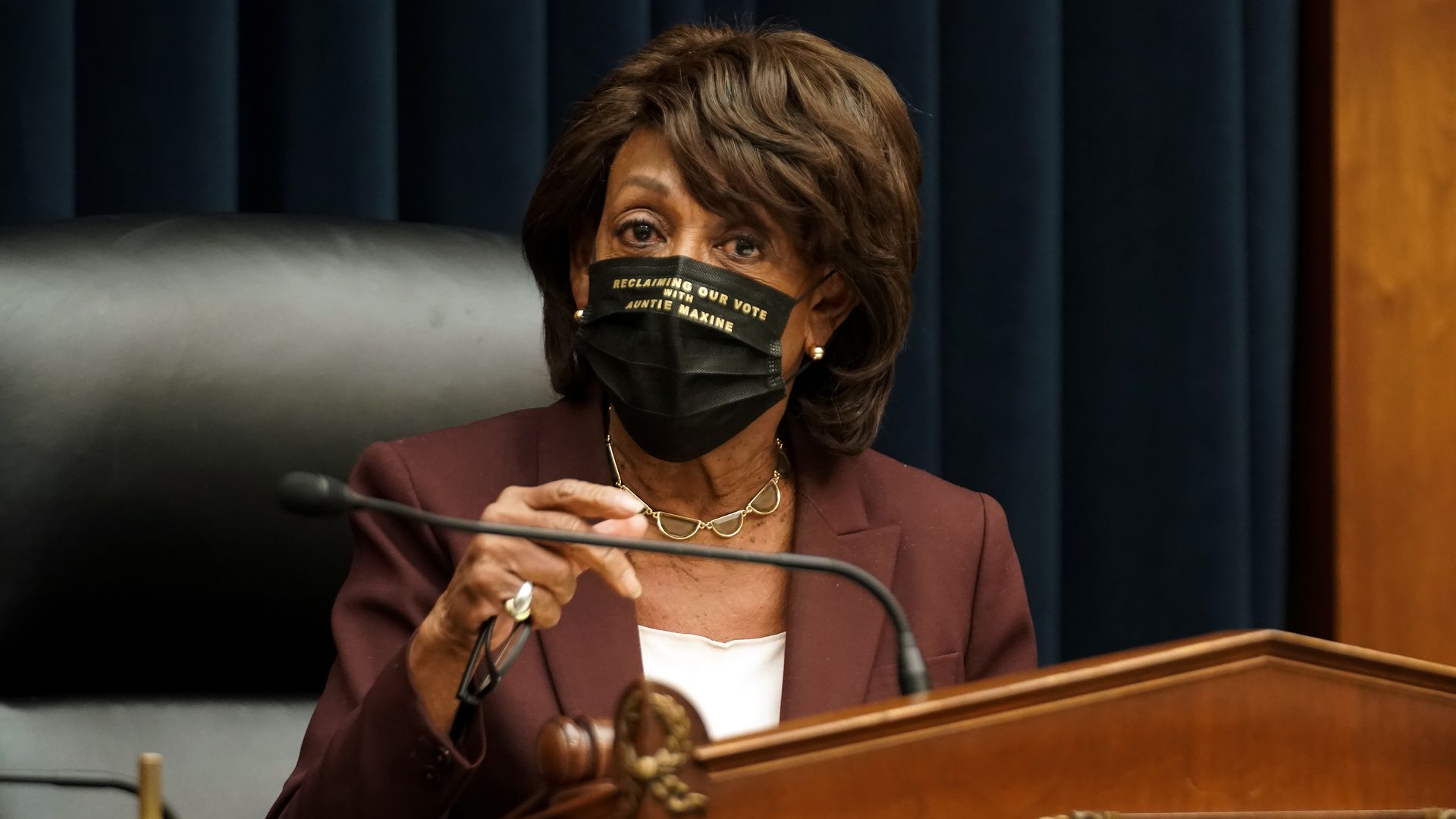 Photo of Rep. Maxine Waters, masked at a podium during a hearing