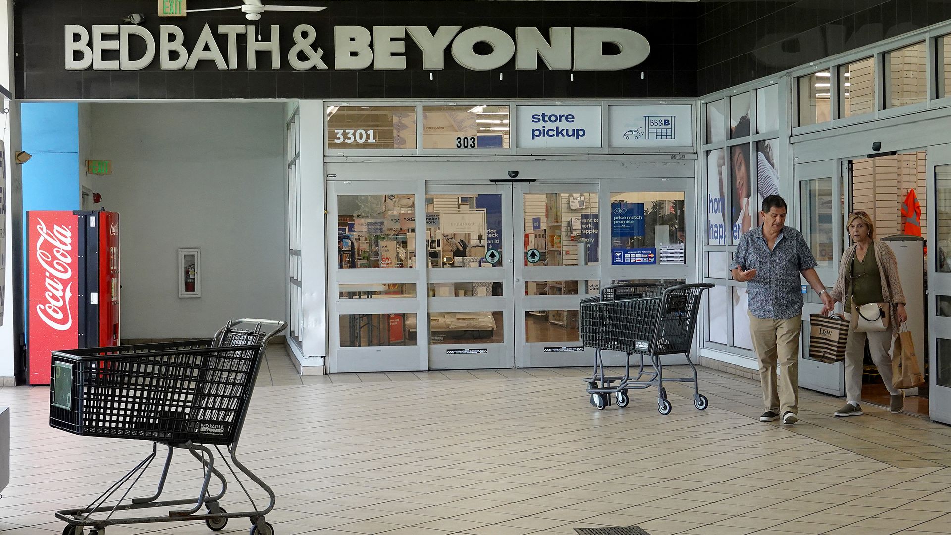 An empty shopping cart sits in front the entrance to one of Bed Bath & Beyond's retail stores.
